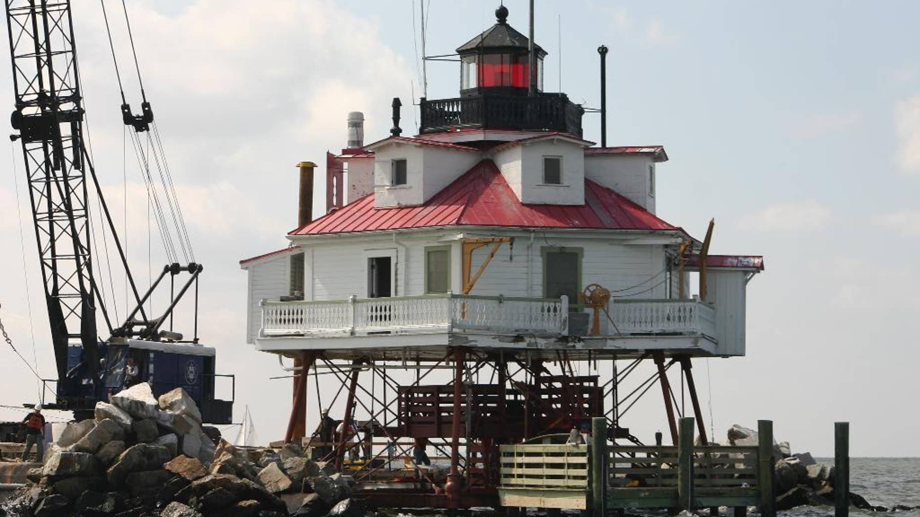 FILE - In this June 6, 2007 file photo, a barge works alongside the Thomas Point Shoal Lighthouse near Annapolis, Md., as part of a renovation project on the structure. Authorities are investigating a break-in and vandalism at the historic lighthouse in Maryland. Maryland Natural Resources Police say the lighthouse was targeted between April 15 and April 16, 2016. (AP Photo/Brian Witte)
