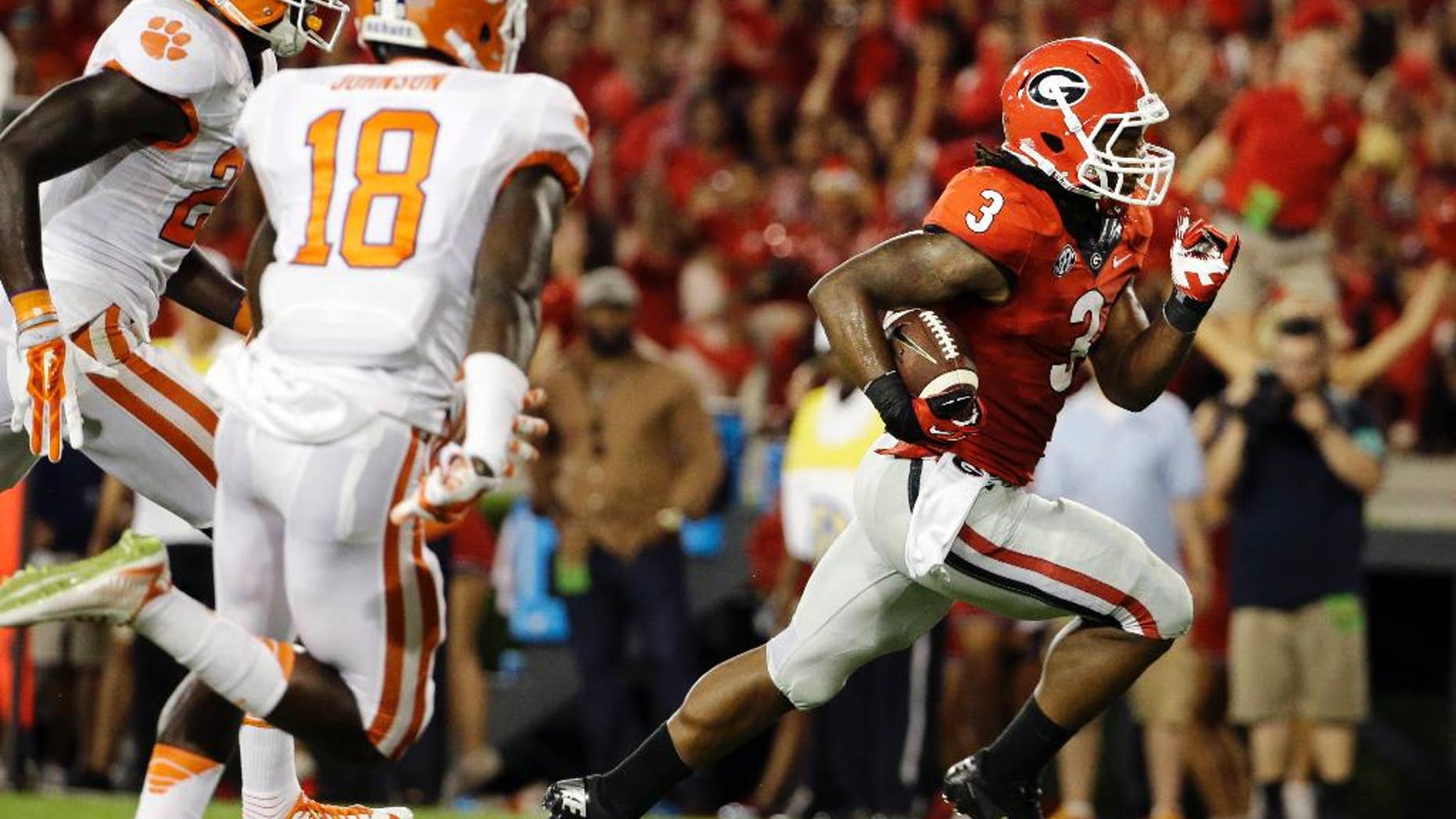 Georgia's Todd Gurley, right, runs the ball to score a touchdown in the second half of an NCAA college football game against Clemson, Saturday, Aug. 30, 2014, in Athens, Ga. Gurley ran for 198 yards and three touchdowns, returned a kickoff 100 yards for another score, and No. 12 Georgia gained some early style points in the national race with a 45-21 victory over No. 16 Clemson on Saturday night. (AP Photo/David Goldman)