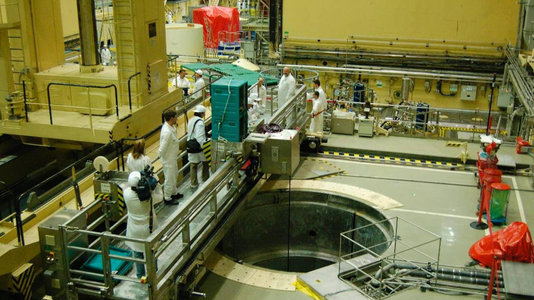 FILE - In this Jan. 29, 2007 file photo, International media representatives look at the recovered cleaning tank of shaft one of reactor block two of the Paks Nuclear Power Plant, where disturbance in the cooling of fuel rods occurred in 2003, in Paks, some 90 kms south of Budapest, Hungary, The European Union has cleared Hungary to build two nuclear reactors with Russian help after Budapest made commitments to safeguard competition in the energy sector. (Peter Kiss G./MTI via AP,file)