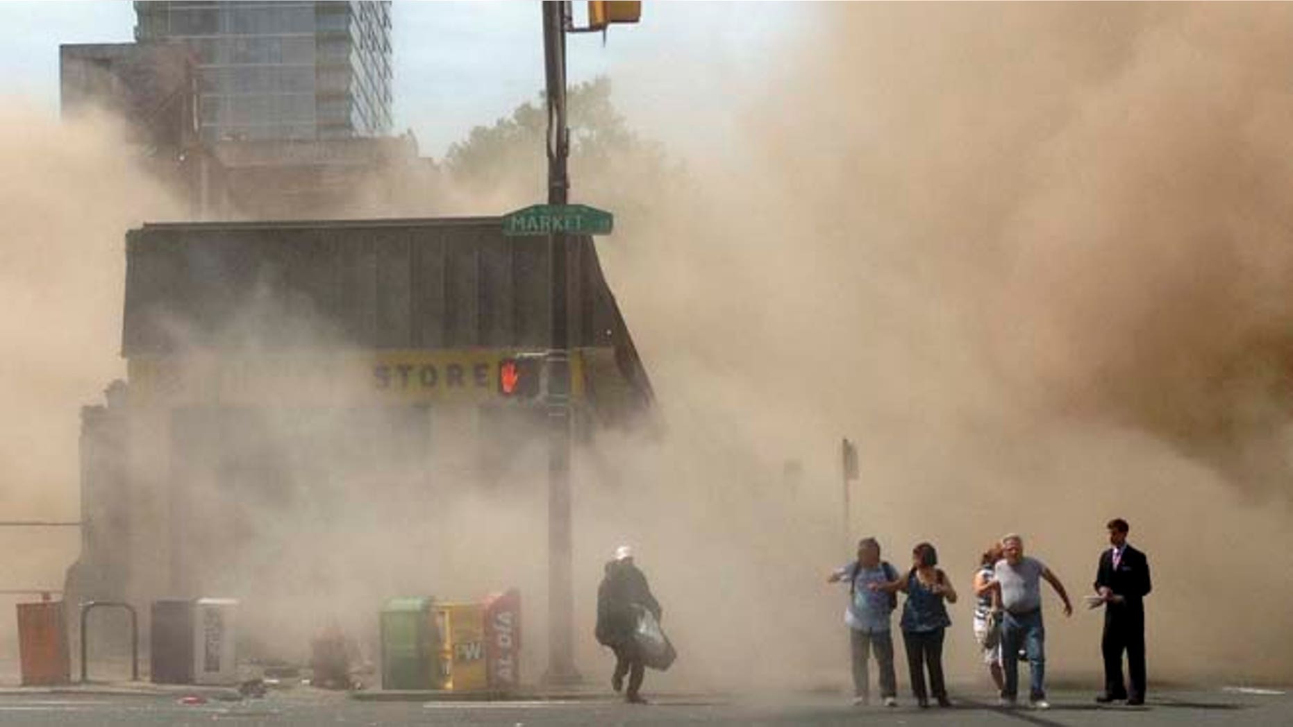 June 5, 2013: In this photo provided by Jordan McLaughlin, a dust cloud rises as people run from the scene of a building collapse on the edge of downtown Philadelphia. (AP)