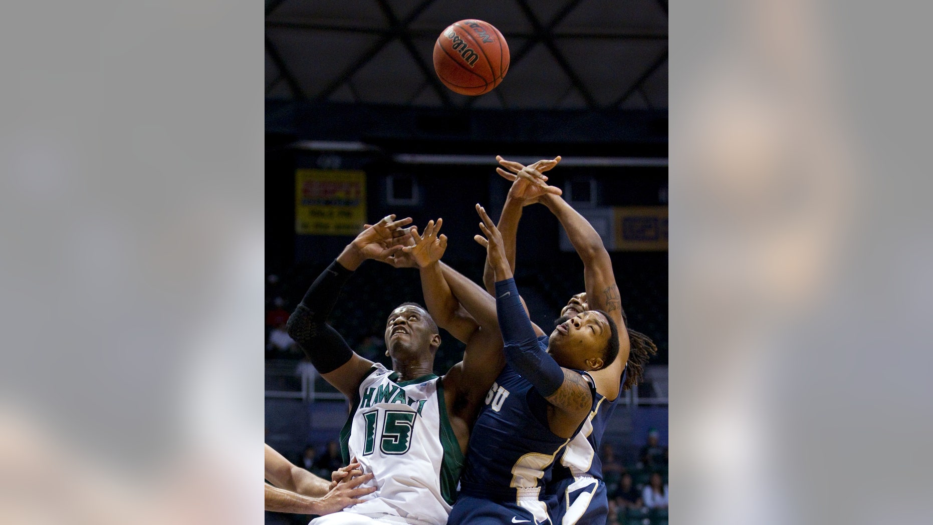Hawaii center Vander Joaquim (15), East Tennessee State guard Jarvis Jones, right, and his teammate forward Hunter Harris, right rear, look up for a rebound in the first half of an NCAA college basketball game in the Diamond Head Classic, Sunday, Dec. 23, 2012, in Honolulu. (AP Photo/Eugene Tanner)