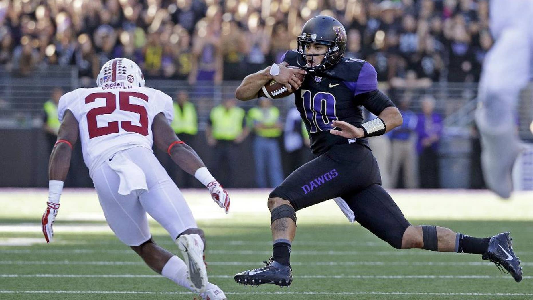 Washington quarterback Cyler Miles(10) is chased by Stanford's Alex Carter in the second half of an NCAA football game Saturday, Sept. 27, 2014, in Seattle. Stanford won 20-13.(AP Photo/Elaine Thompson)