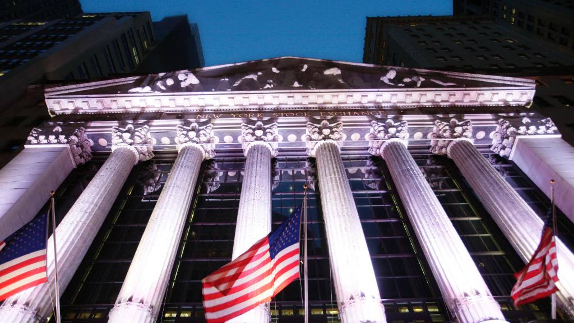 In this Wednesday, Oct. 8, 2014 photo, American flags fly in front of the New York Stock Exchange, in New York. A strong report on job creation pushed stock indexes higher Friday, Dec. 5, 2014, even though the figures may prompt the Federal Reserve to raise interest rates sooner than anticipated. The dollar rose as traders anticipated more robust growth in the U.S. (AP Photo/Mark Lennihan)