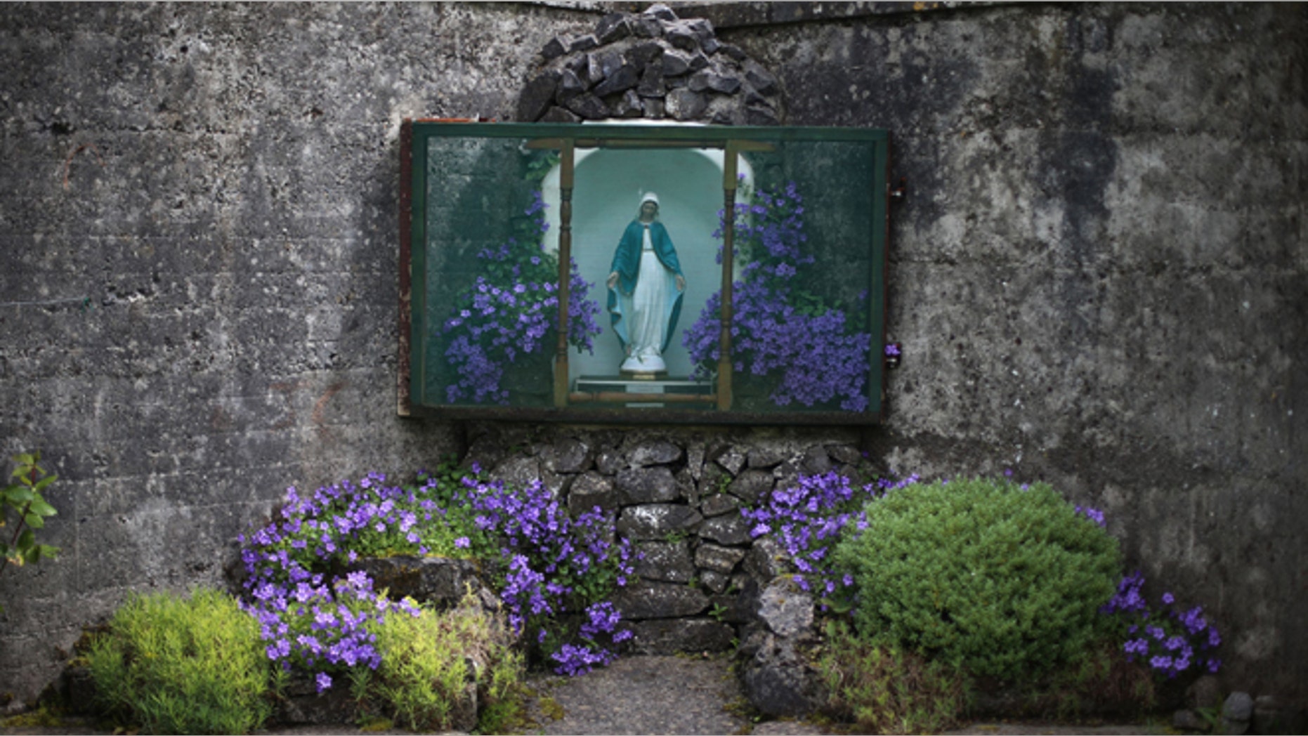 June 4, 2014: A statue of the Virgin Mary adorns the site of a mass grave for children who died in the Tuam mother and baby home in Tuam, Ireland. (AP/Niall Carson/PA)
