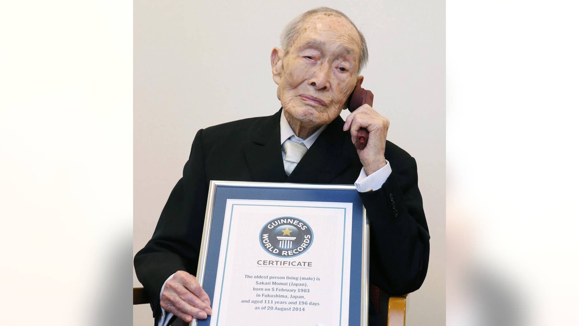FILE - In this Aug. 20, 2014 file photo, Sakari Momoi, a Japanese retired educator, poses for a photo after receiving a certificate from Guinness World Records as Momoi was recognized as the world’s oldest living man, in Tokyo. An official at Saitama City said Tuesday, July 7, 2015 that Sakari Momoi died on Sunday at a nursing home in Tokyo. He was 112. (Kyodo News via AP, File) JAPAN OUT, CREDIT MANDATORY