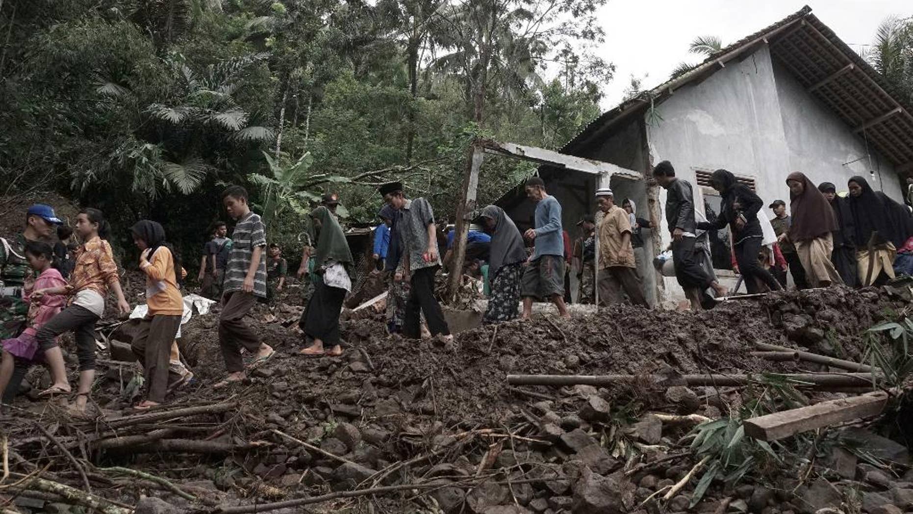 Villagers walk through an area wrecked by landslides in Banjarnegara, Central Java, Indonesia.