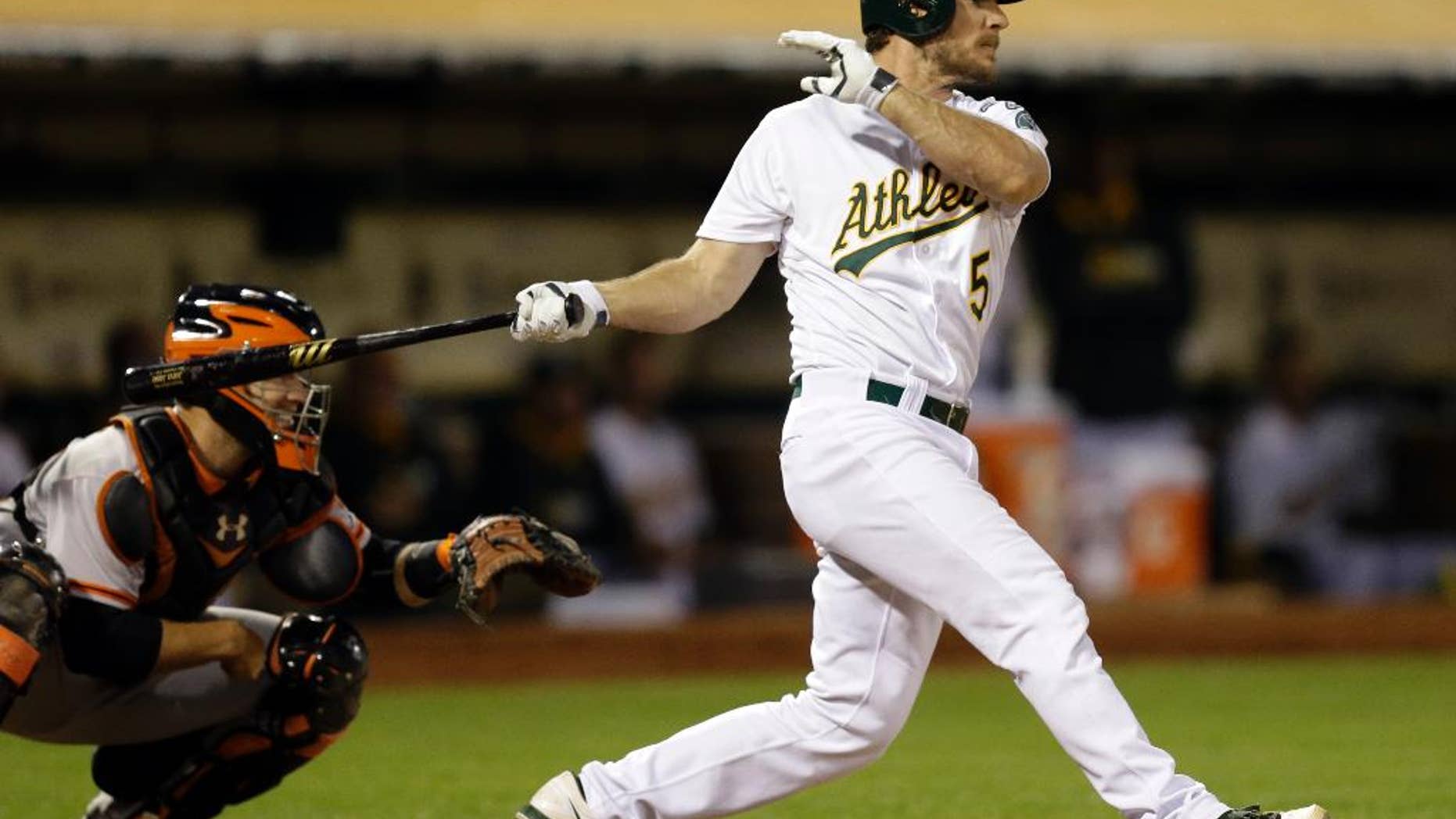 Oakland Athletics' John Jaso swings for an RBI ground out against the San Francisco Giants in the fifth inning of a baseball game Monday, July 7, 2014, in Oakland, Calif. (AP Photo/Ben Margot)
