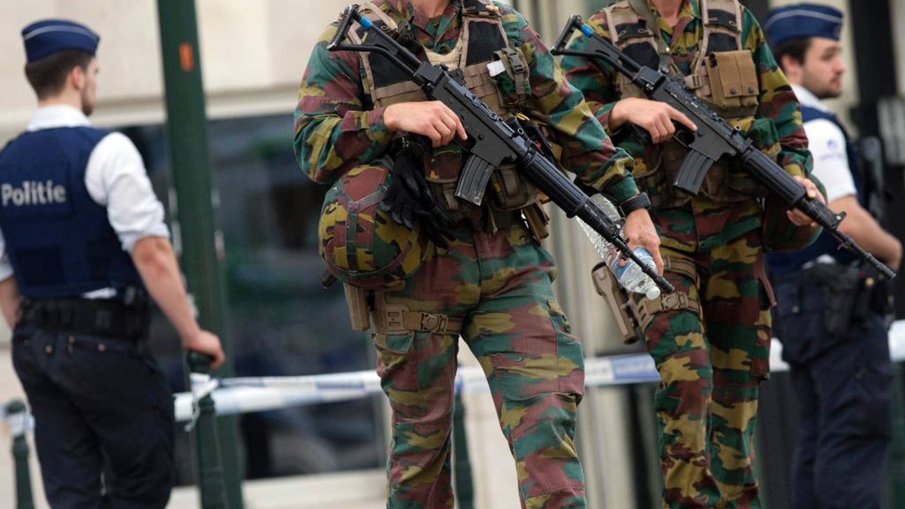 FILE - In this June 23, 2016, file photo, folice and Belgian Army soldiers patrol during a court hearing for suspect Mohamed Abrini, a suspect in the Paris and Brussels attacks, that were claimed by the Islamic State organization, at the Court of Appeals in Brussels. The threat of violence by people inspired by foreign extremists invokes fear in a majority of young Americans across racial groups. But for young people of color, particularly African Americans, that fear is matched or surpassed by worries about violence from white extremists. A new GenForward poll of Americans age 18-30 shows widespread anxiety among young people about attacks from both inside and outside the United States. (AP Photo/Virginia Mayo, File)