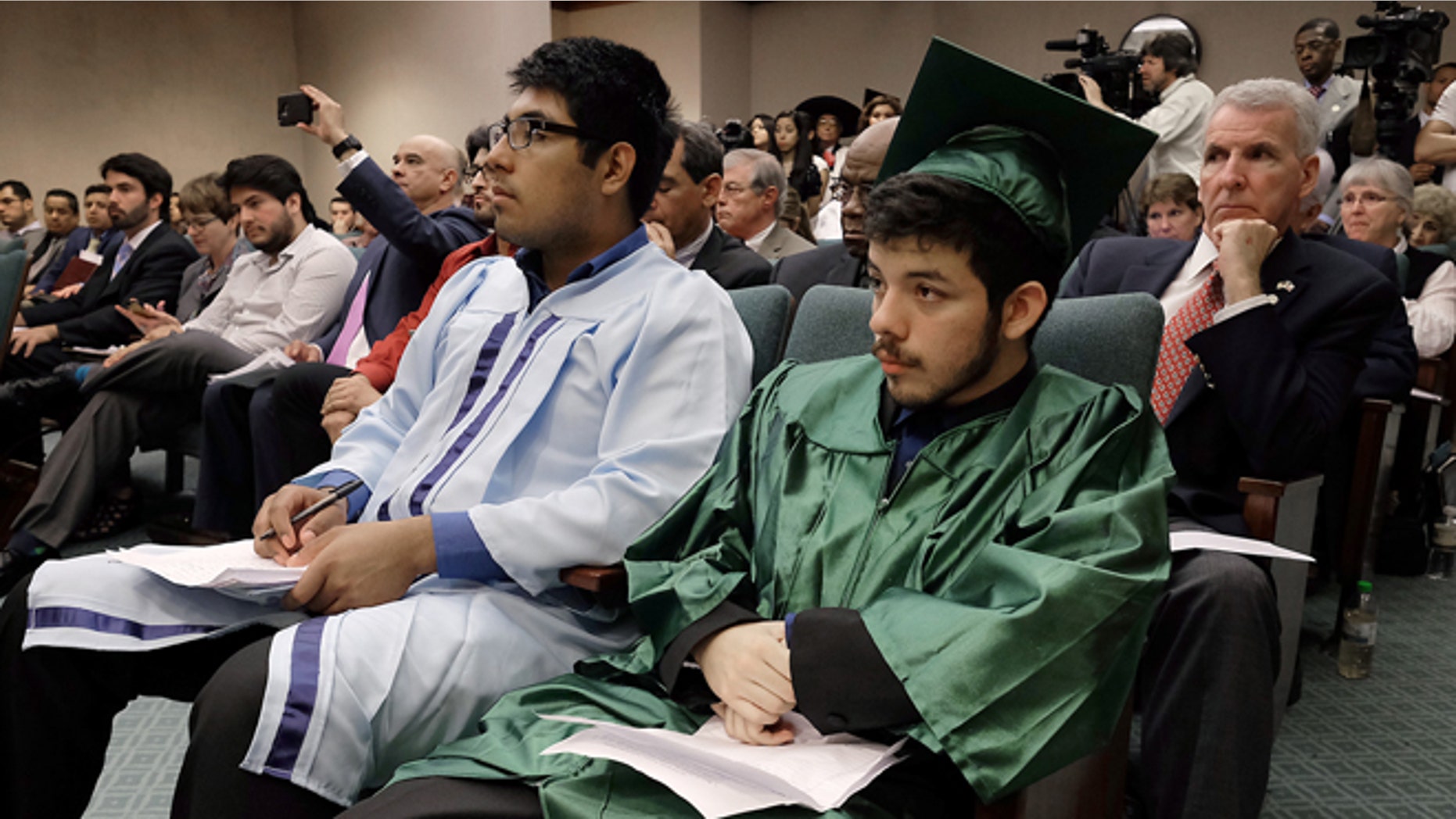 Erick Dominquez, of Houston, left, and Jesus Trevino sit in the front row of hearing committee room waiting to testify against a repeal of the so-called "Texas Dream Act" of 2001, in Austin, Texas, Monday, April 6, 2015. The Republican-controlled Legislature began a push Monday to repeal Texas' 14-year-old law that gives the children of some people living in the United States illegally in-state tuition at public universities.(AP Photo/Austin American-Statesman, Rodolfo Gonzalez) AUSTIN CHRONICLE OUT, COMMUNITY IMPACT OUT, INTERNET AND TV MUST CREDIT PHOTOGRAPHER AND STATESMAN.COM, MAGS OUT