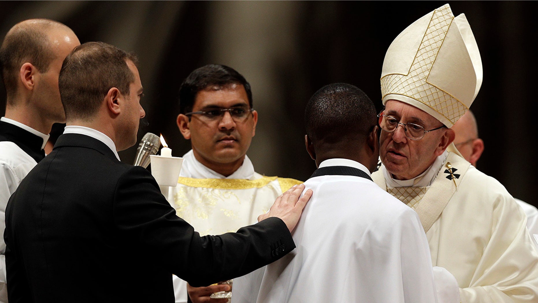 Pope Francis baptizes John Ogah as he presides over a solemn Easter vigil ceremony in St. Peter's Basilica at the Vatican, Saturday, March 31, 2018.