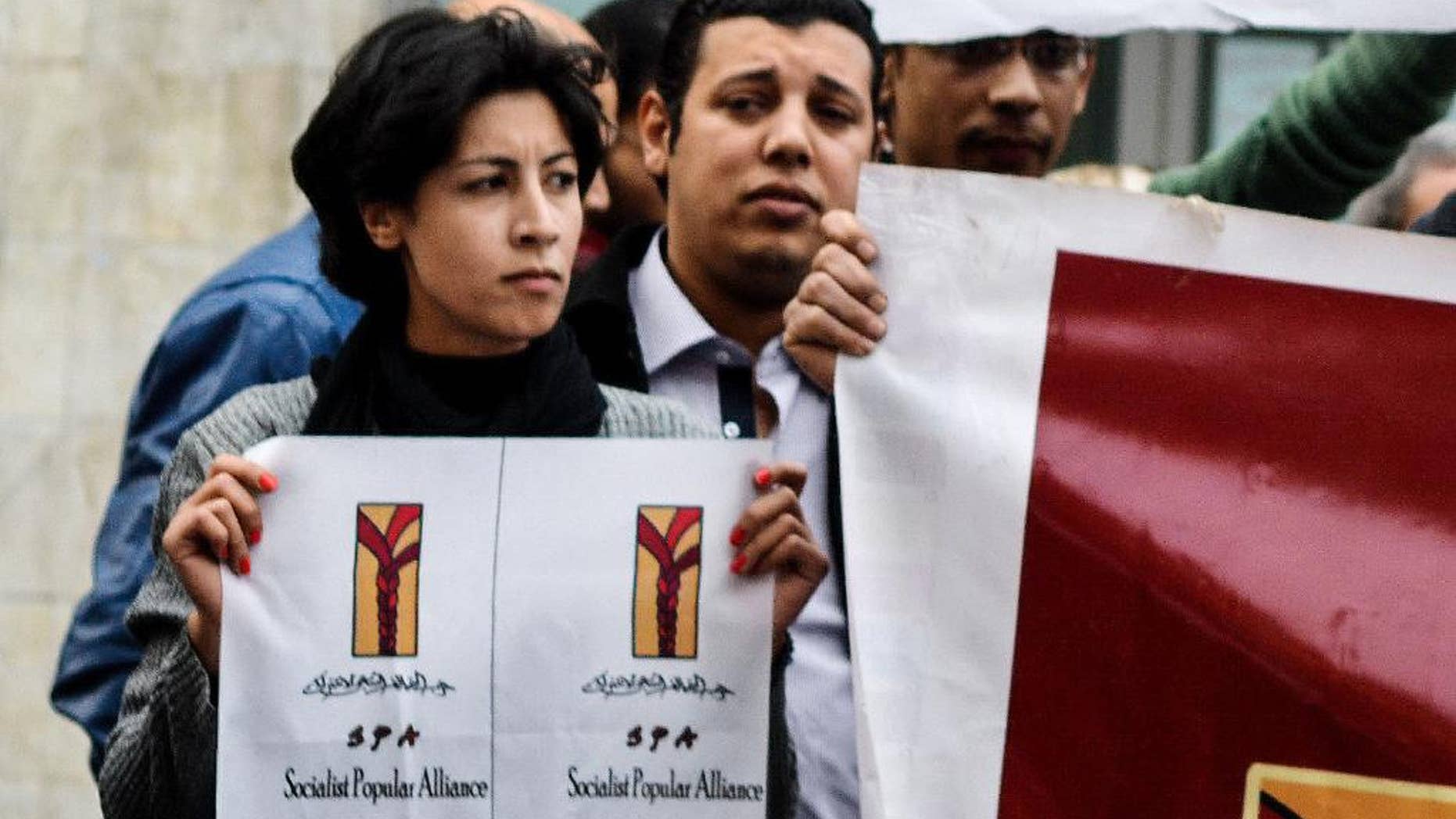 FILE - In this Jan. 24, 2015 photo, 32-year-old mother Shaimaa el-Sabbagh holds a poster during a protest in downtown Cairo. An Egyptian court acquitted 17 people on Saturday, May 23, 2015, over taking part in an unsanctioned demonstration earlier this year that saw a young mother shot to death in downtown Cairo. At least one of those affected by the court's decision is a witness to the killing of el-Sabbagh, an unarmed protester taking part in a peaceful demonstration. (AP Photo/Mohammed El-Raaei, File)