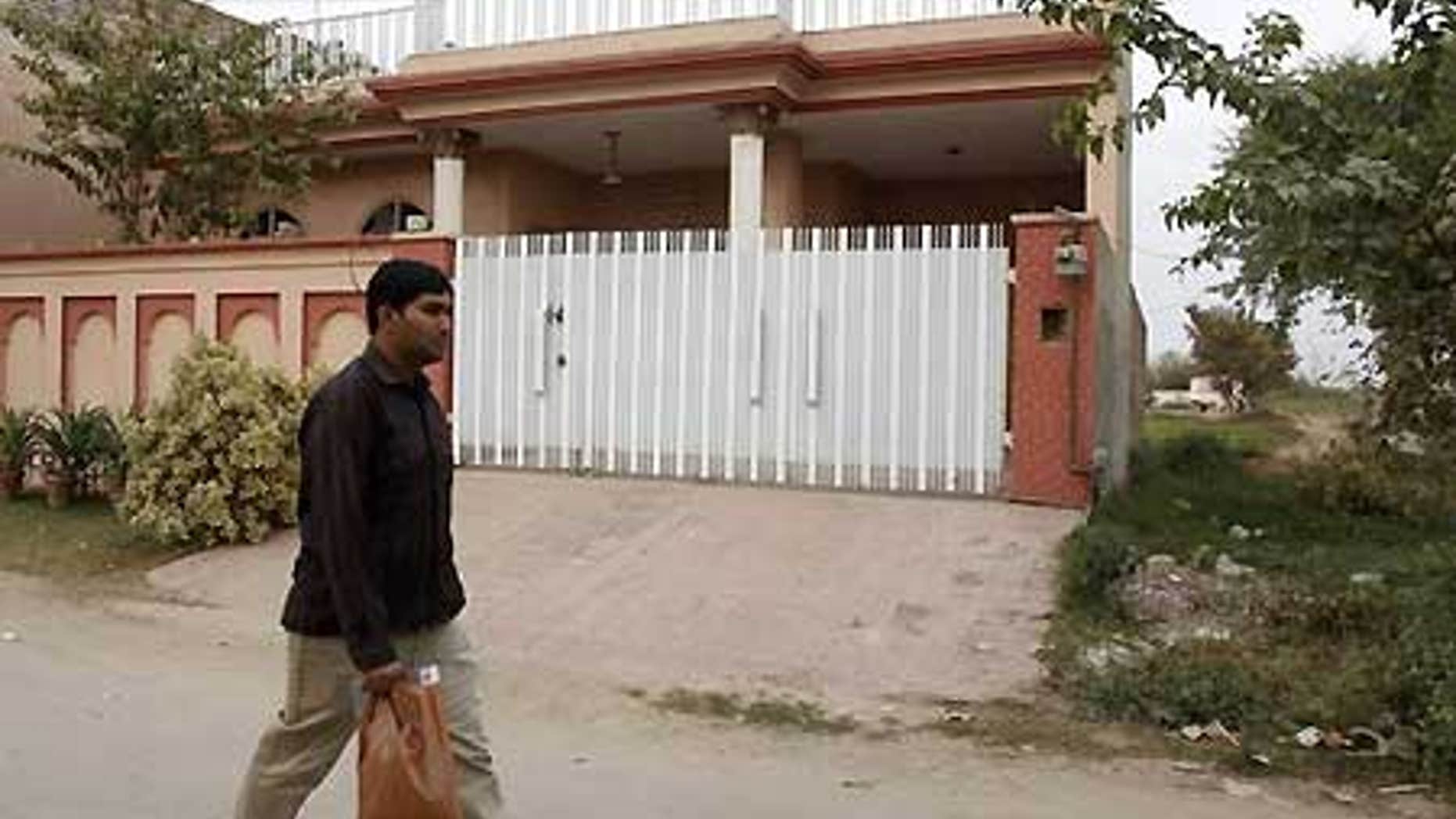 Dec. 10: A man walks past a house which residents say was raided by Pakistani security forces during the arrest of five Americans.