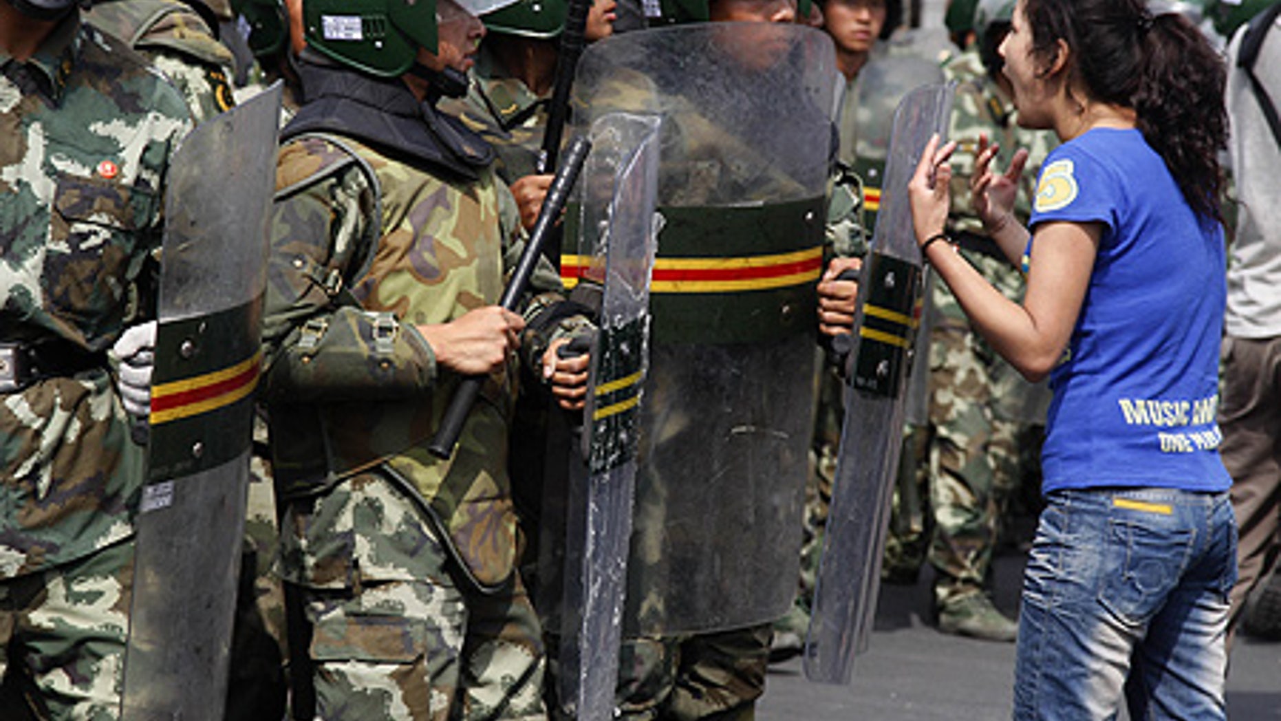 July 7: An Uighur woman protests before a group of paramilitary police in Urumqi, China.