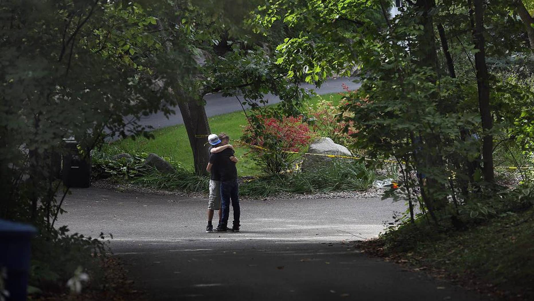 Nick Collins, right, embraces Minnetonka High School classmate Nathan Kahn during a visit Friday, Sept. 11, 2015, to the scene where five family members were found inside a home in Greenwood, Minn. Police pushed ahead Friday with their investigation into an apparent murder-suicide in the affluent Minneapolis suburb that left a family of five dead, while a high school offered counseling to classmates of the three children. (Jim Gehrz/Star Tribune via AP) MANDATORY CREDIT; ST. PAUL PIONEER PRESS OUT; MAGAZINES OUT; TWIN CITIES LOCAL TELEVISION OUT
