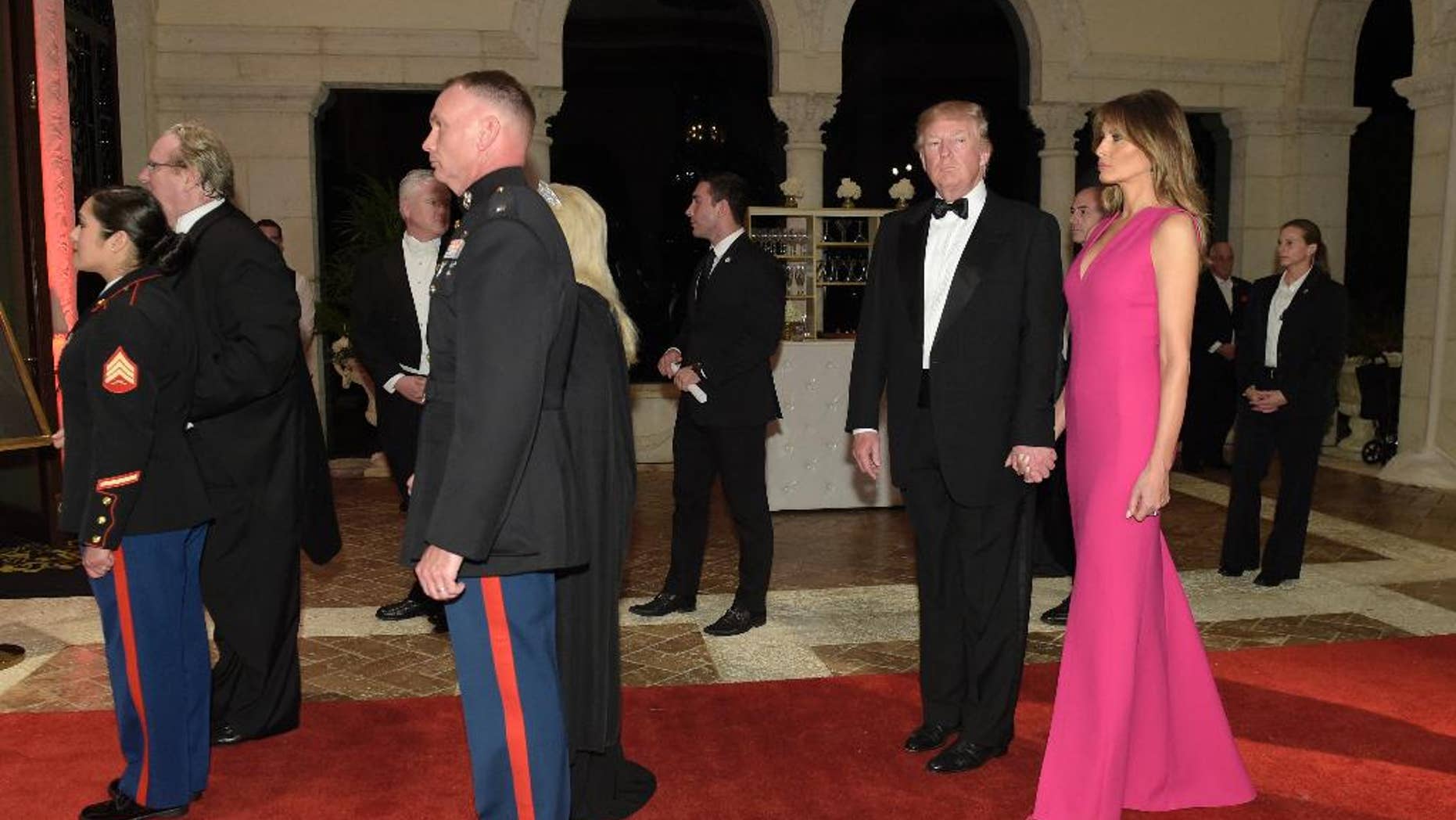 President Donald Trump and first lady Melania Trump arrive for the 60th annual Red Cross Gala at Trump's Mar-a-Lago resort in Palm Beach, Fla., Saturday, Feb. 4, 2017. (AP Photo/Susan Walsh)