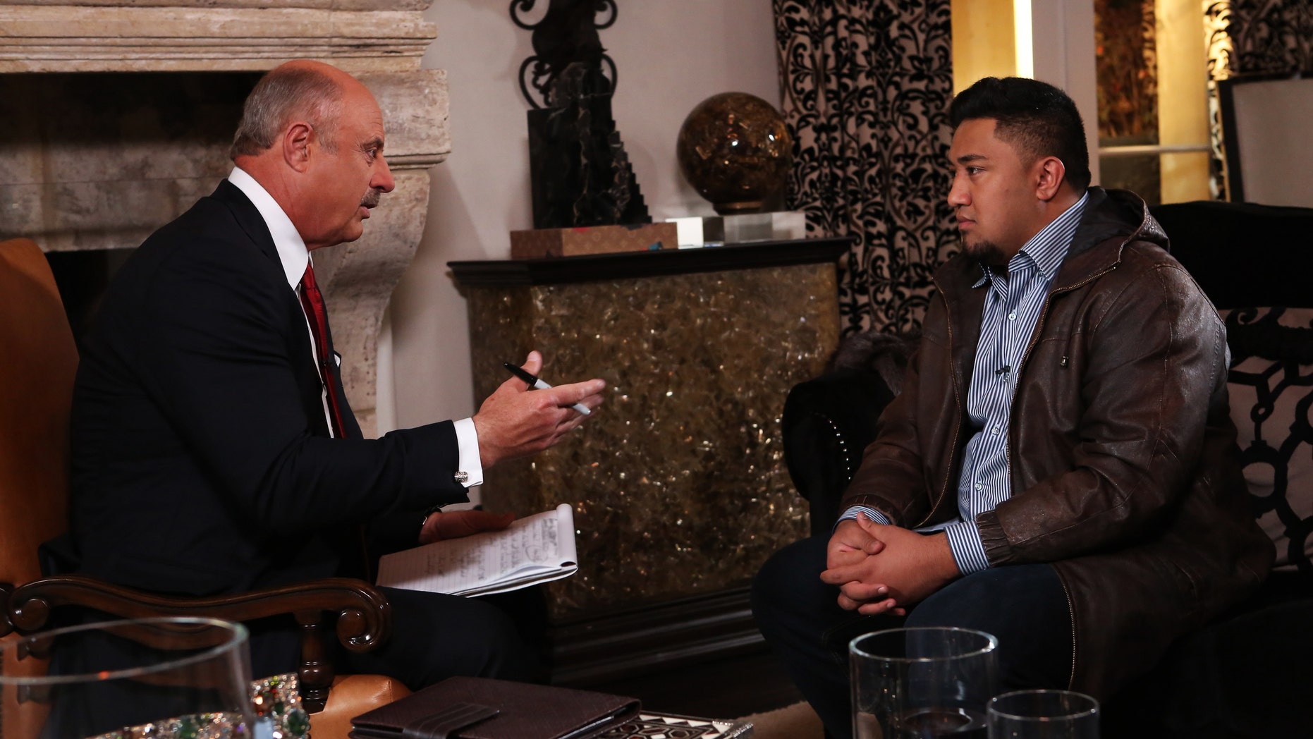 In this Jan. 24, 2013, photo provided by CBS Television Distribution/Peteski Productions, talk show host Dr. Phil McGraw, left, interviews Ronaiah Tuiasosopo during taping for the "Dr. Phil Show" in Los Angeles. The program, scheduled to air Thursday, Jan. 31, and Friday, Feb. 1, will show the first on-air interview of Tuiasosopo, the man who allegedly concocted the girlfriend hoax that ensnared Notre Dame football star Manti Te'o. (AP Photo/CBS Television Distribution/Peteski Productions)