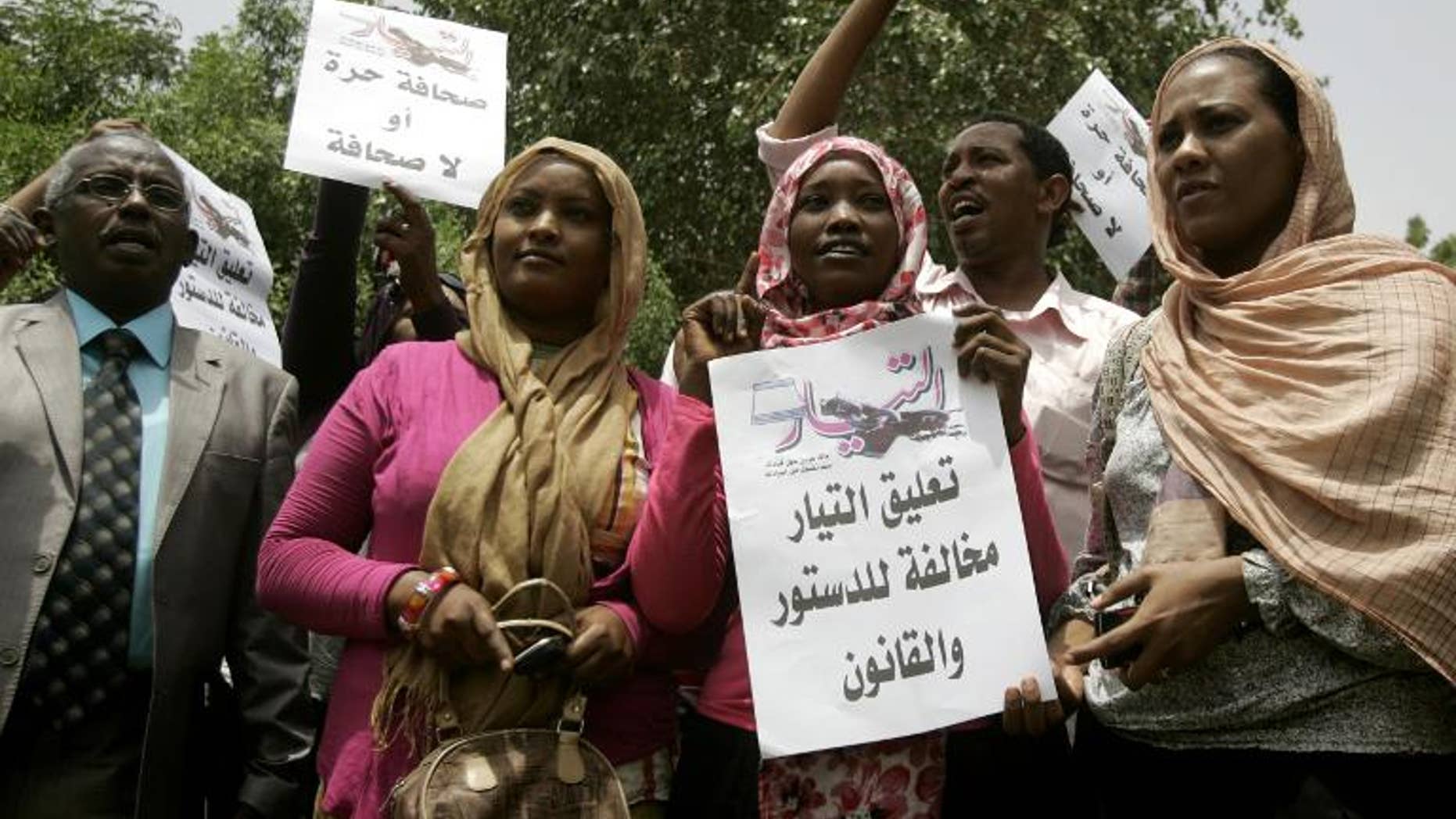 Sudanese journalists hold slogans which read in Arabic "Press freedom or no press" and " Suspension of Al-Tayyar daily is against the constitution and law" in Khartoum on July 17, 2012