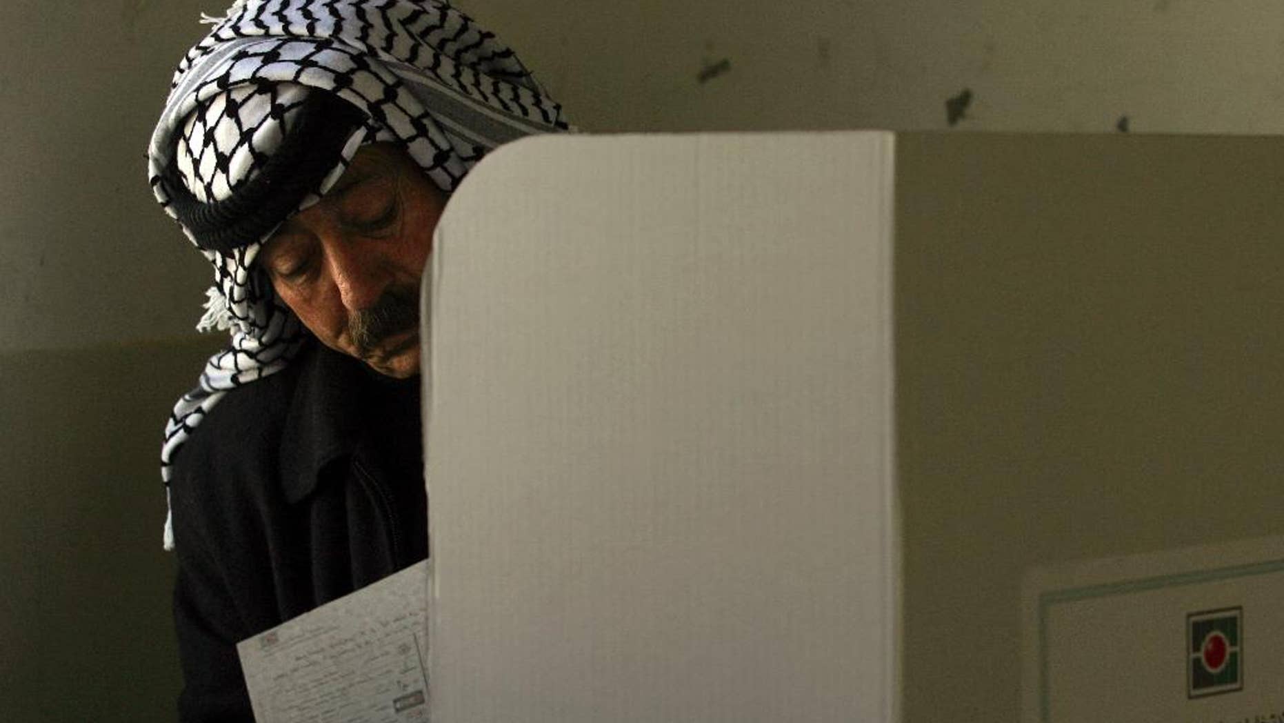 FILE - In this Jan. 22, 2006 file photo, a Palestinian police officer fills in his ballot before casting it in parliamentary elections in the West Bank city of Nablus. The Palestinian high court on Monday, Oct. 3, 2016 ruled upcoming municipal elections will be held in the West Bank only, excluding the Hamas-controlled Gaza Strip, in a move that suspends the first political contest in a decade between the rival Fatah and Hamas in both territories. (AP Photo/Emilio Morenatti, File)