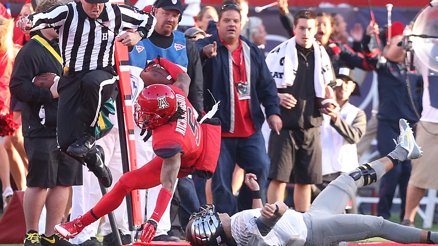 University of Arizona cornerback Shaquille Richardson (5) is knocked out of bounds by Oregon quarterback Marcus Mariota (8) after he picked off Mariota's pass during the fourth quarter at Arizona Stadium in Tucson on Nov. 23, 2013. Arizona upset Oregon. (AP Photo/Arizona Daily Star, Mike Christy)