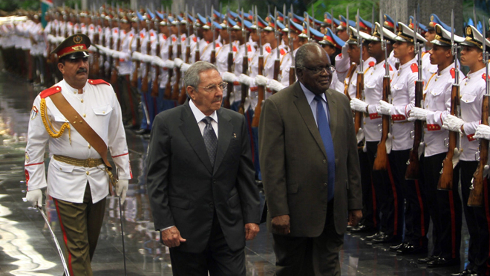 Cuba's President Raul Castro, center, and Namibia's President Hifikepunye Pohamba, right, review an honor guard in Havana, Cuba, Monday, Sept 29, 2014. Pohamba is on a three-day official visit to Cuba. (AP Photo/Ismael Francisco, Cubadebate)