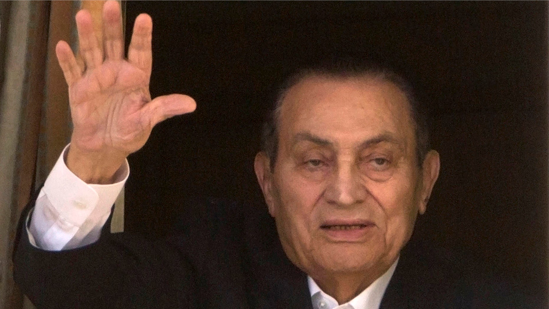 In this April 25, 2016 file photo, ousted Egyptian President Hosni Mubarak waves to his supporters from his room at the Maadi Military Hospital, where he is hospitalized, as they celebrate Sinai Liberation Day that marks the final withdrawal of all Israeli military forces from Egypt's Sinai Peninsula in 1982, in Cairo, Egypt.