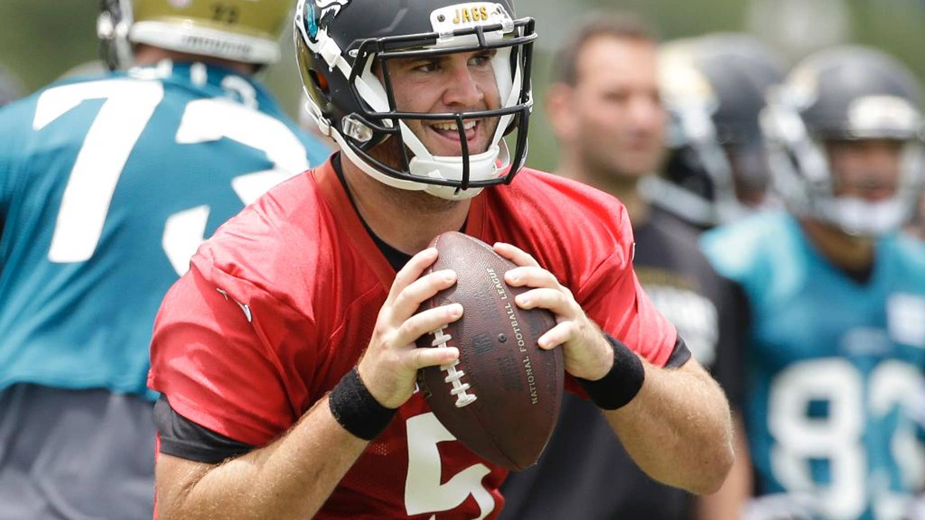 FILE - In this June 18, 2014, file photo, Jacksonville Jaguars quarterback Blake Bortles (5) looks for a receiver during a team scrimmage at NFL football minicamp in Jacksonville, Fla. The majority of teams pay their starting quarterbacks just a fraction of the base salaries of the Peyton Mannings, Tom Brady and Jay Cutler, who makes $17.5 million this season.(AP Photo/John Raoux, File)
