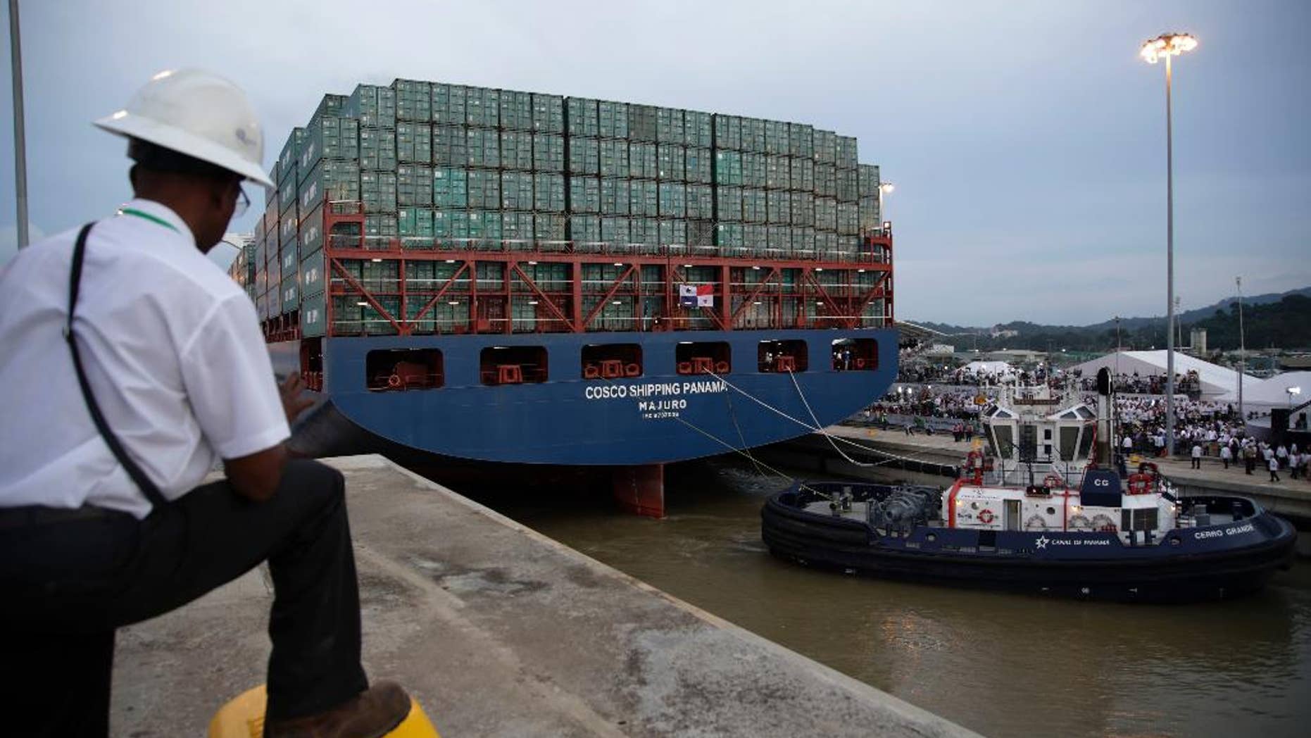 FILE - In this June 26, 2016, file photo, a worker watches as the COSCO Shipping Panama cargo ship leaves the new Cocoli Locks, part of the new Panama Canal expansion project, in Panama City. Canal administrator Jorge Quijano said Tuesday, July 26, that a Chinese container ship brushed with the canal’s new wider locks due to bad weather and the ship not lining up correctly. (AP Photo/Tito Herrera, File)