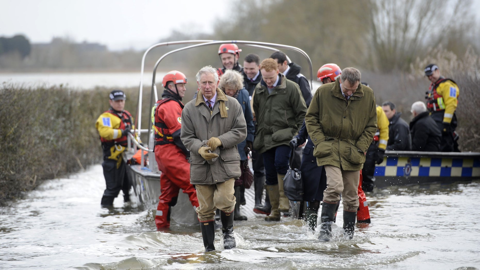 Britain's Prince Charles, centre, walks through flood water after travelling to the flood-hit community of Muchleney and meeting with a local farming family at Thorney Moor Farm, to see the damage caused by the flood waters, Somerset, England, Tuesday, Feb. 4, 2014. (AP Photo/PA, Ben Birchall) UNITED KINGDOM OUT, NO SALES, NO ARCHIVE