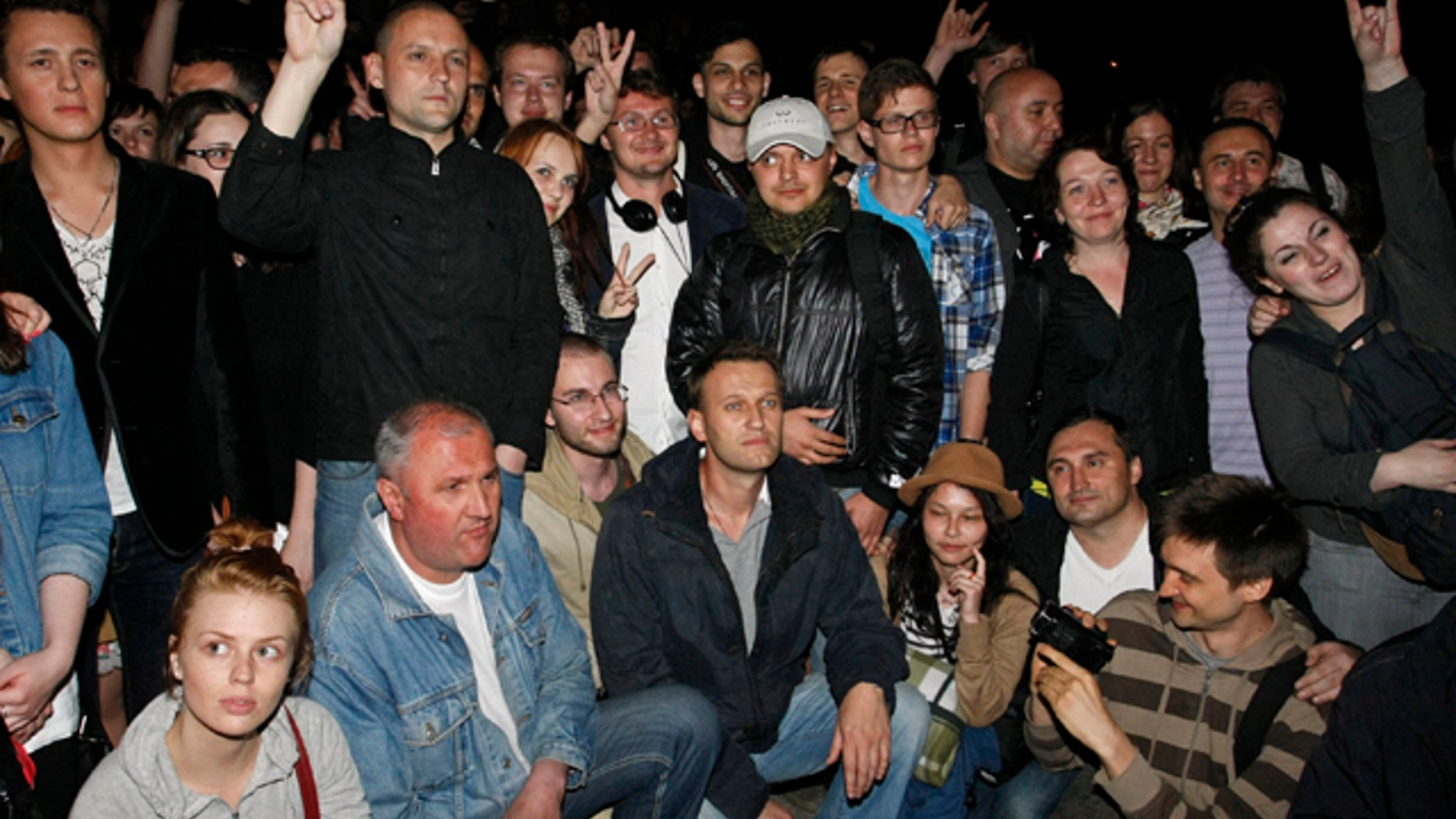May 8, 2012: Alexei Navalny, at bottom center, a prominent anti-corruption whistle blower and blogger, and opposition leader Sergei Udaltsov, standing at second from left, pose with protesters gathering in the opposite side of the Presidential administrations building in downtown Moscow early Tuesday, a day after Vladimir Putin's inauguration.