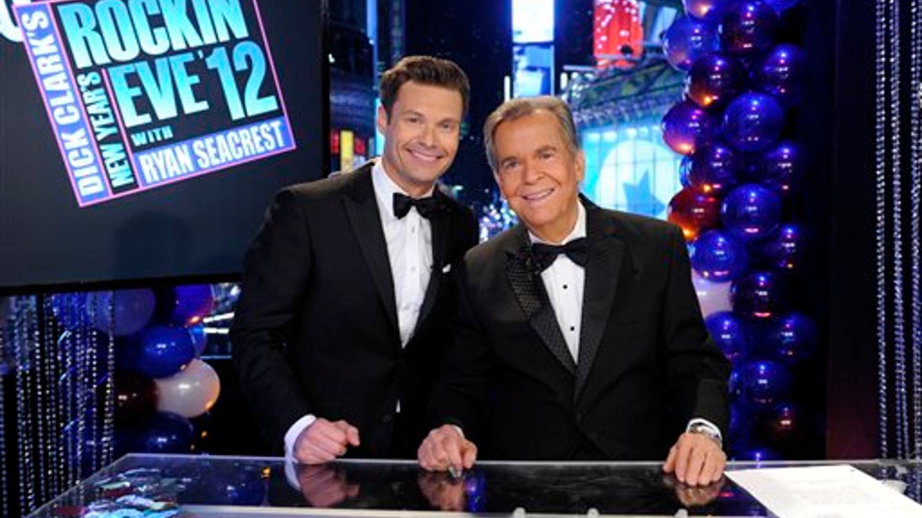 In this Dec. 31, 2011 photo released by ABC, hosts Dick Clark, right, and Ryan Seacrest pose on the set of "Dick Clark's New Year's Rockin' Eve with Ryan Seacrest 2012" in Times Square in New York. (AP Photo/ABC, Ida Mae Astute)