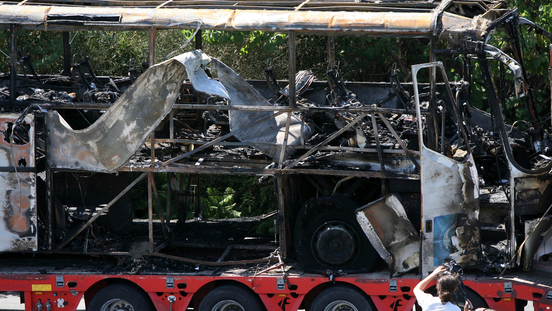FILE - In this Thursday, July 19, 2012 file photo a damaged bus is transported out of Burgas airport, Bulgaria, a day after a deadly suicide attack on a bus full of Israeli vacationers. U.S. officials expect Bulgarian investigators to link the militant group Hezbollah to the July 18 attack in the coastal city of Burgas, in which a bomb ripped through a bus that was taking the tourists to their hotel. Bulgarian authorities are expected to release their findings on Tuesday Feb. 5, 2013. (AP Photo/ Impact Press Group, File)