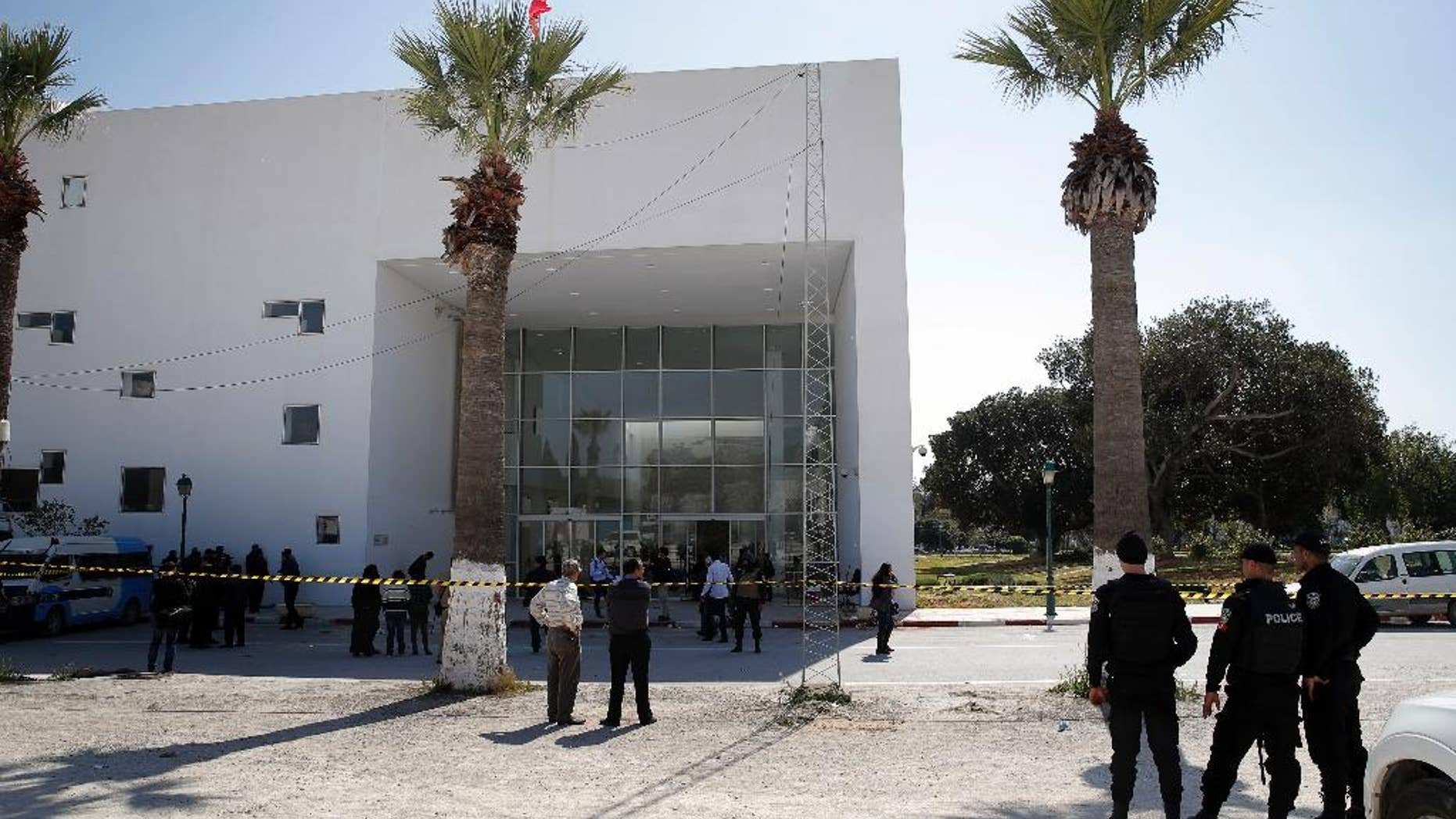 Policemen guard the entrance of the Bardo museum in Tunis, Tunisia, Thursday, March 19, 2015, a day after gunmen opened fire killing over 20 people, mainly tourists. One of the two gunmen who killed tourists and others at a prominent Tunisian museum was known to intelligence services, Tunisia's prime minister said Thursday. But no formal links to a particular terrorist group have been established in an attack that threatens the country's fledgling democracy and struggling tourism industry. (AP Photo/Christophe Ena)
