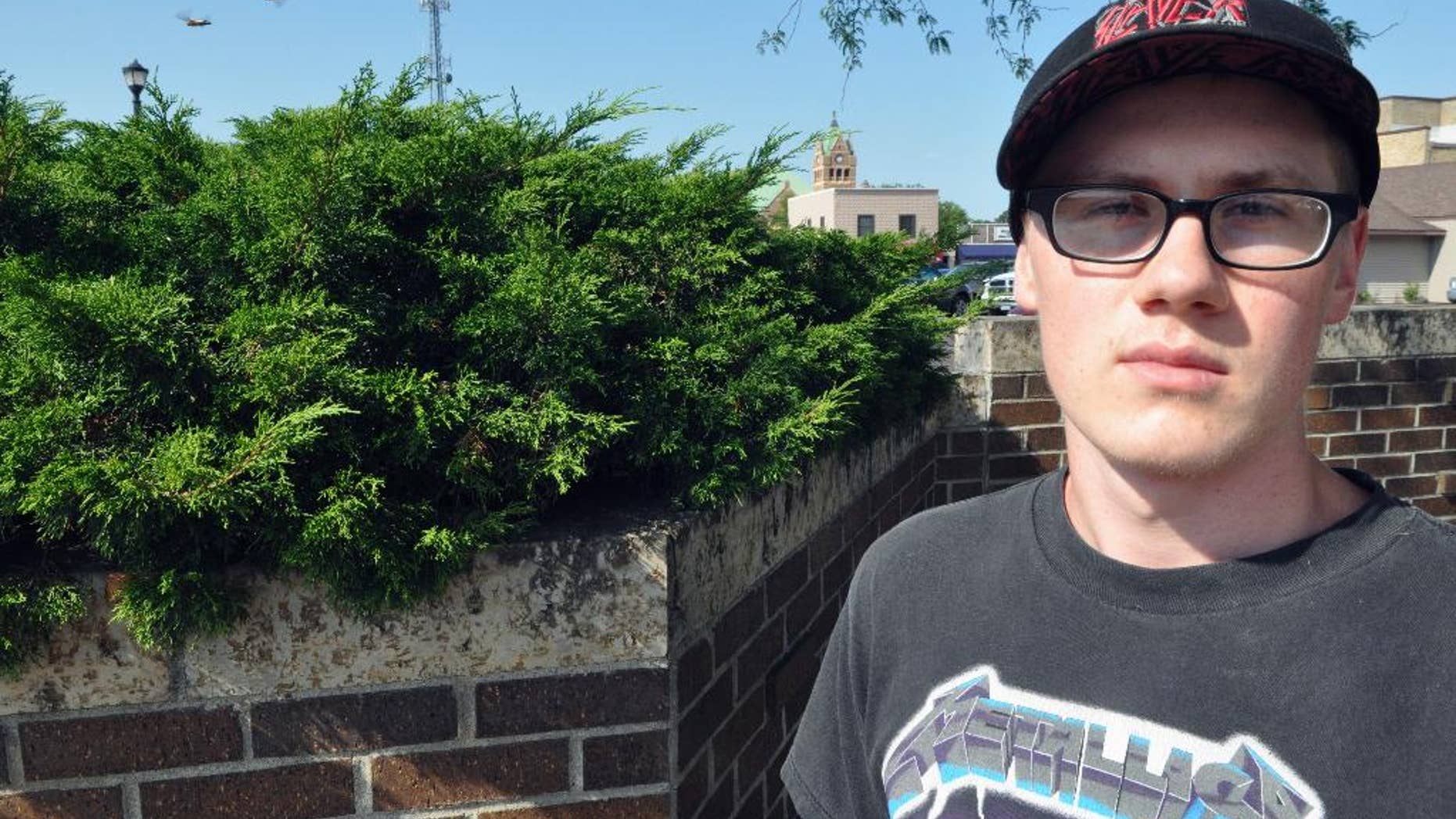 In this Aug. 4, 2016, photo, provided by the Waseca County News, John LaDue poses for a photo in downtown Waseca, Minn. LaDue, who planned an attack at his school in 2014, says he made "a very bad decision" to stockpile bomb-making materials and wishes he hadn't done it. LaDue was released from probation last month and has been living at his parents' home in Waseca since May. (Dana Melius/Waseca County News via AP)