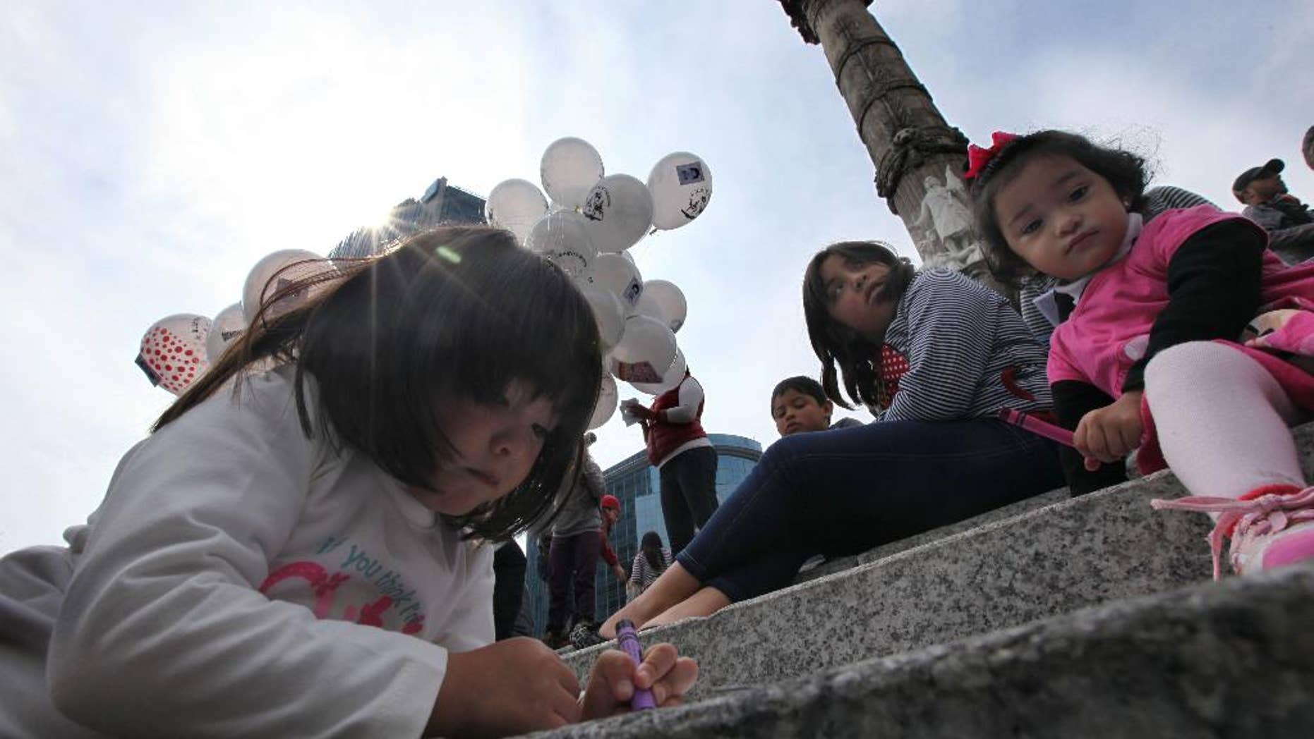 Children write letters for the feast of the Three Kings, asking for the 43 missing colleges students, in Mexico City, Sunday Jan. 4, 2015. The children along with their parents sent letters asking for the well being of the students that went missing after a clash with the local police of the town of Iguala on Southern Guerrero state, on Sept. 26, 2014. (AP Photo/Marco Ugarte)