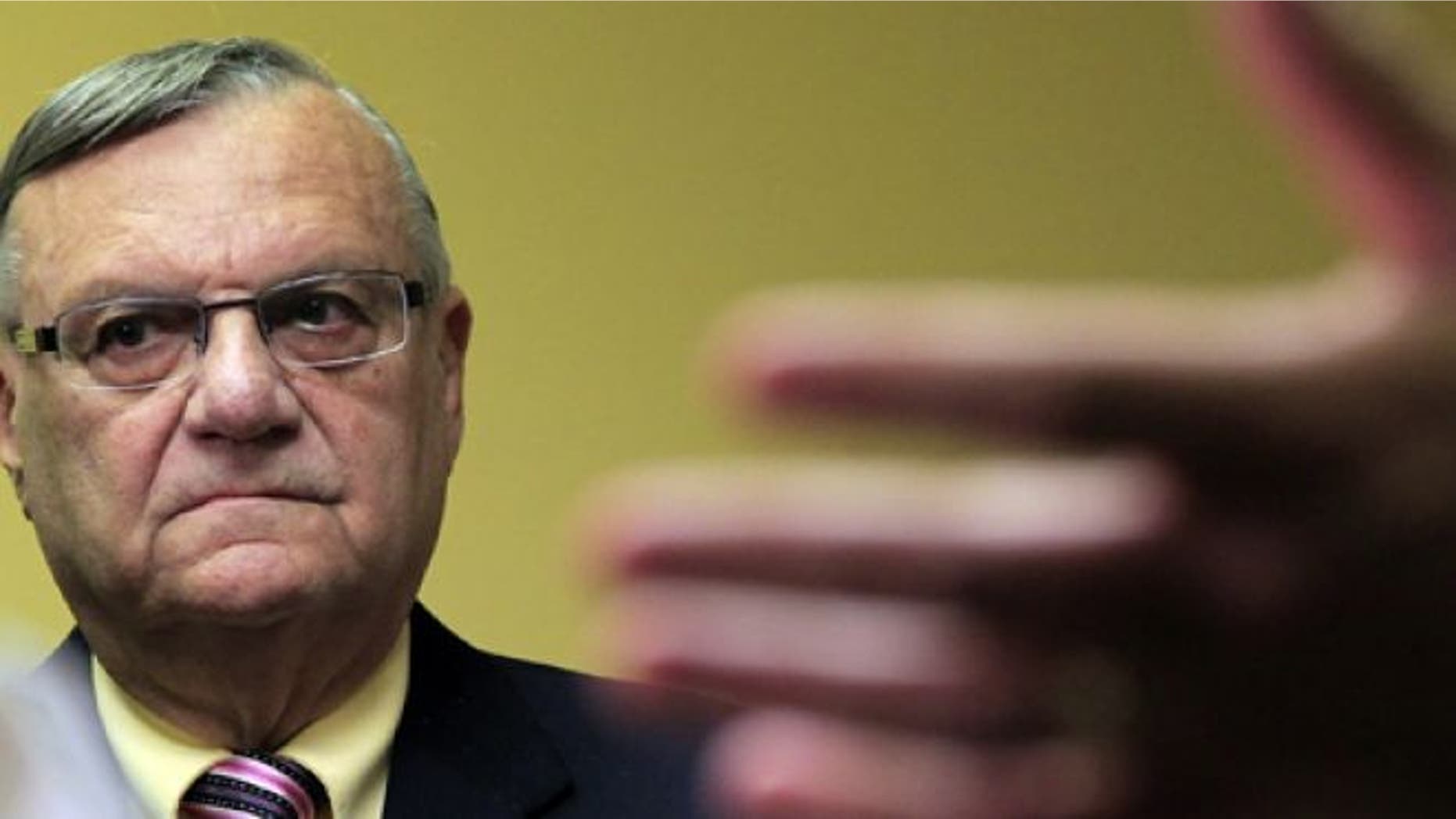 July 24, 2012: Maricopa County Sheriff Joe Arpaio listens to one of his attorneys during a news conference in Phoenix.