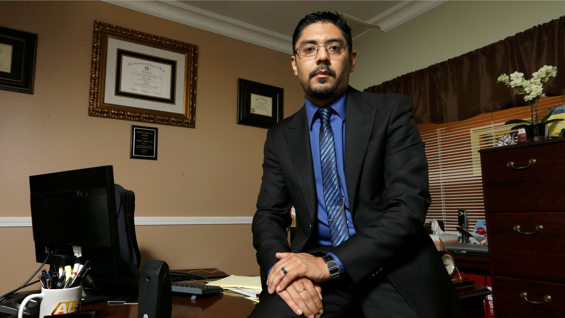 In this Oct. 30, 2014 photo, civil litigation lawyer Sergio Garcia poses in his office in Chico, Calif. Garcia, 37, a native of Mexico, won his license to practice law after a bruising five-year legal and political battle that included a ruling in January from the California Supreme Court. It came after Gov. Jerry Brown signed a specially crafted bill passed by the Legislature to let Garcia practice law. (AP Photo/Rich Pedroncelli)
