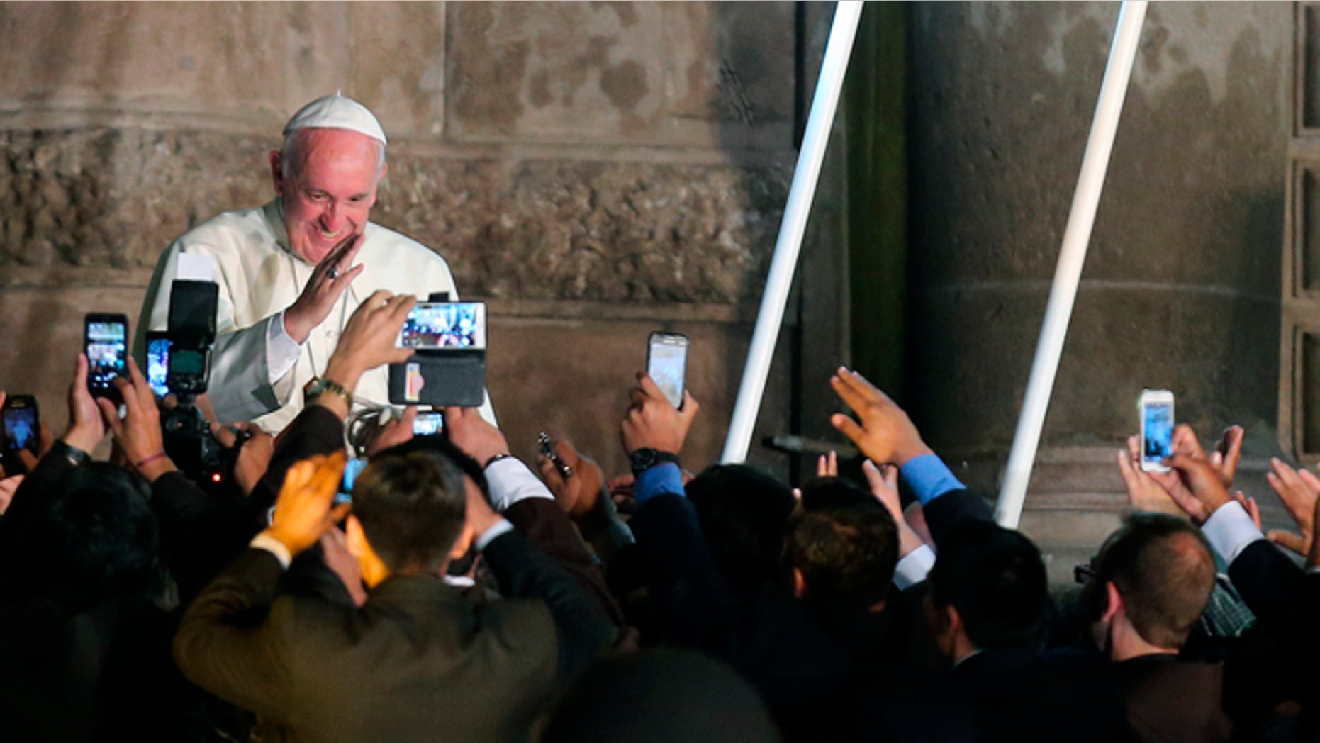Faithful take picture with their mobile phones as Pope Francis departs from the San Francisco Church aboard the Popemobile, in Quito, Ecuador, Tuesday, July 7, 2015. The Pontiff met with representatives of civic organizations, entrepreneurs, indigenous communities and Catholic lay groups. (AP Photo/Fernando Llano)