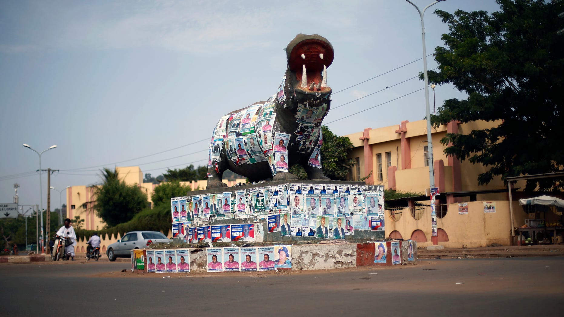 A statue of a hippopotamus is covered with election posters at a traffic circle in Bamako, Mali, Tuesday Nov. 19, 2013. Mali is scheduled to hold parliamentary elections on Sunday, Nov. 24, 2013, in an effort to finalize a return to democracy after a 2012 military coup. Last week residents reported an increase in armed Tuareg rebels in the northern Mali town of Kidal, underscoring the security risks that remain even after a French-led military intervention ousted al-Qaida-linked militants from the major towns in the region. (AP Photo/Jerome Delay)