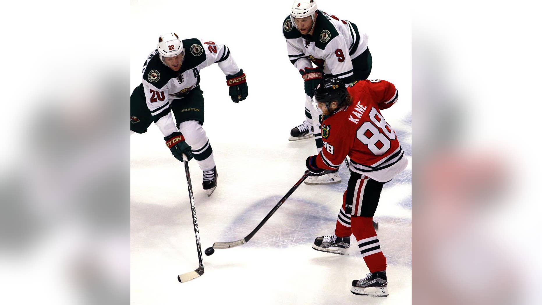 Chicago Blackhawks right wing Patrick Kane (88) shoots against Minnesota Wild defenseman Ryan Suter (20) and center Mikko Koivu (9) during the third period of Game 2 in the second round of the NHL Stanley Cup hockey playoffs in Chicago, Sunday, May 3, 2015. The Blackhawks won 4-1. (AP Photo/Nam Y. Huh)