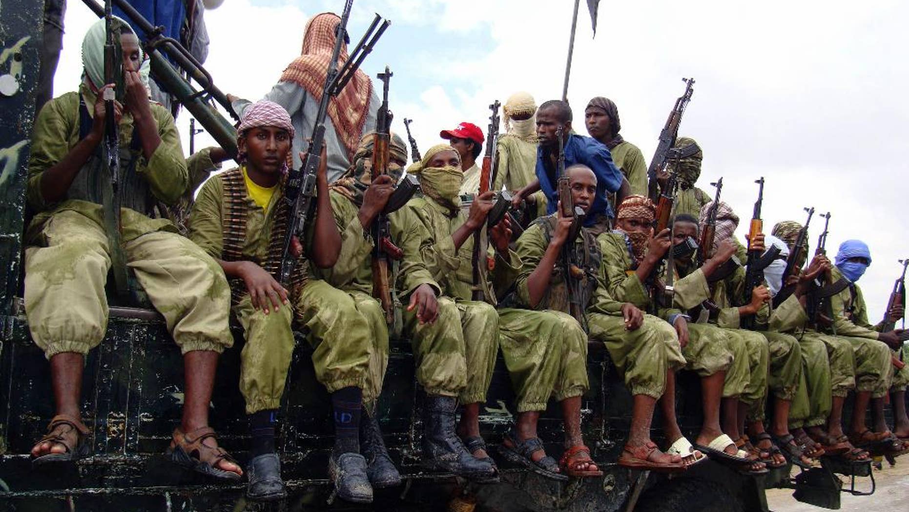 FILE - In this Oct. 30, 2009 file photo, al-Shabab fighters sit on a truck as they patrol in Mogadishu, Somalia. The African Union (AU) peacekeeping mission in Somalia says at least 57 members of the al-Shabab extremist group have been killed Thursday, March 2, 2017 after AU and Somali forces attacked one of its camps. (AP Photo/Mohamed Sheikh Nor, File)