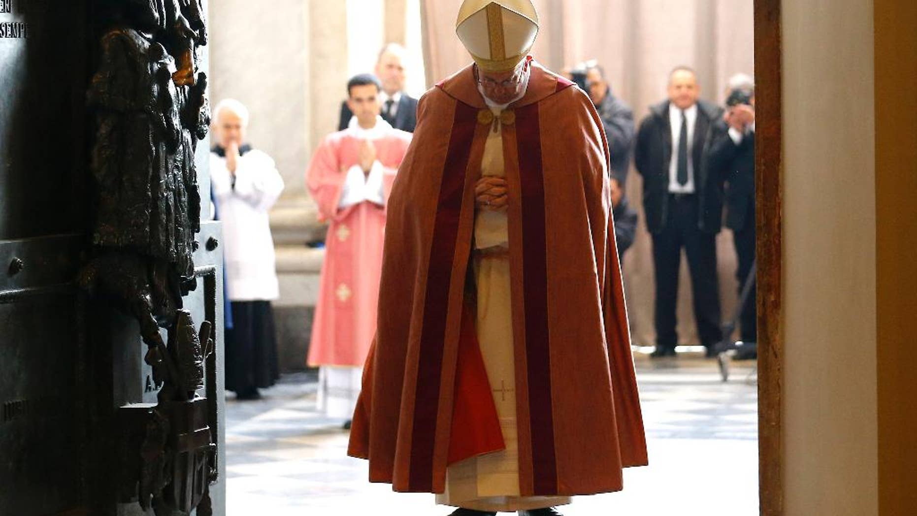 Pope Francis stands after opening the Holy Door of St. John in Lateran Basilica in Rome, Sunday, Dec. 13, 2015. (Stefano Rellandini/Pool Photo via AP)