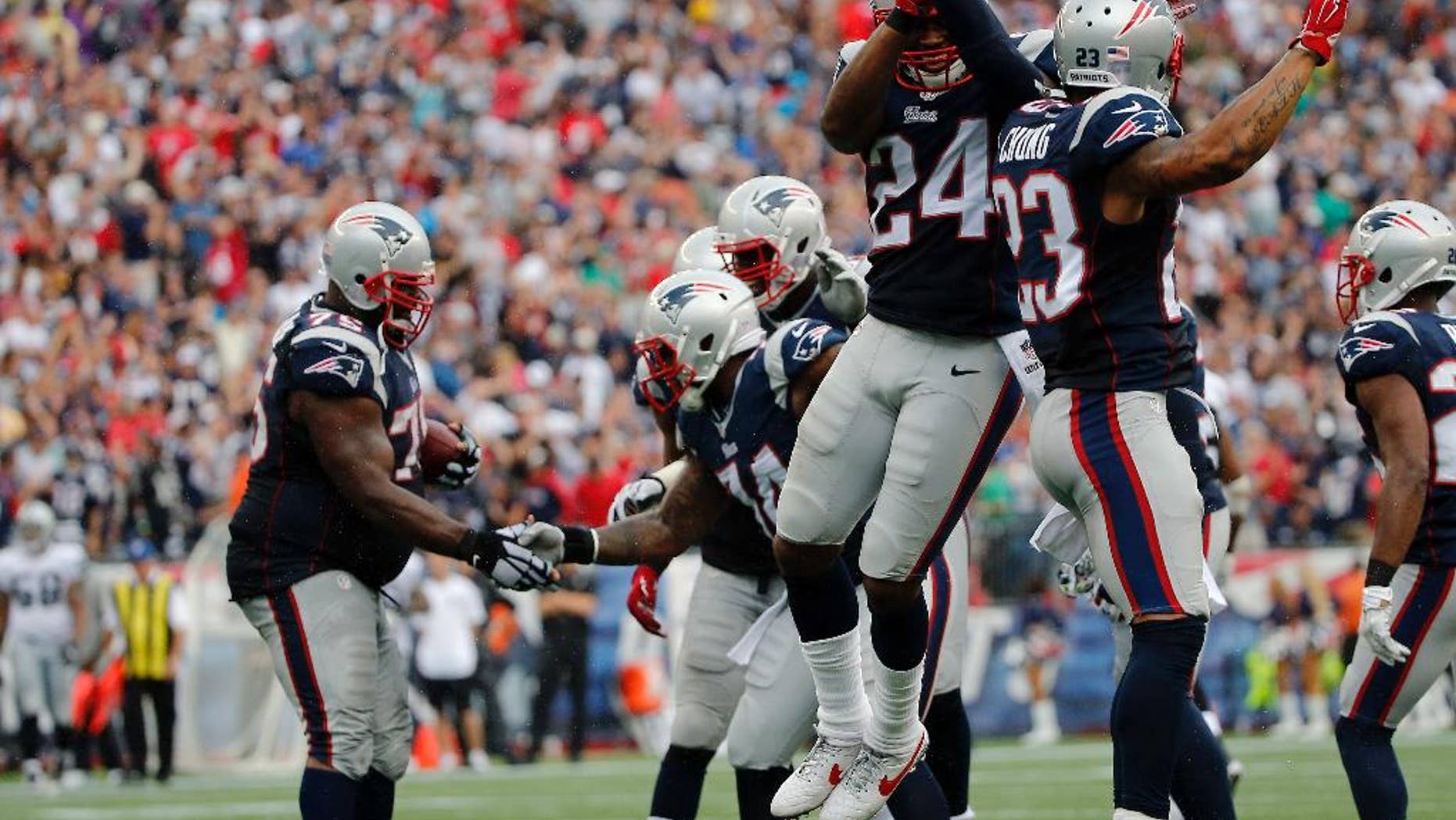 New England Patriots defensive backs Darrelle Revis (24) and Patrick Chung (23) celebrate an interception by Vince Wilfork, left, in the fourth quarter of an NFL football game against the Oakland Raiders, Sunday, Sept. 21, 2014, in Foxborough, Mass. The Patriots won 16-9. (AP Photo/Elise Amendola)