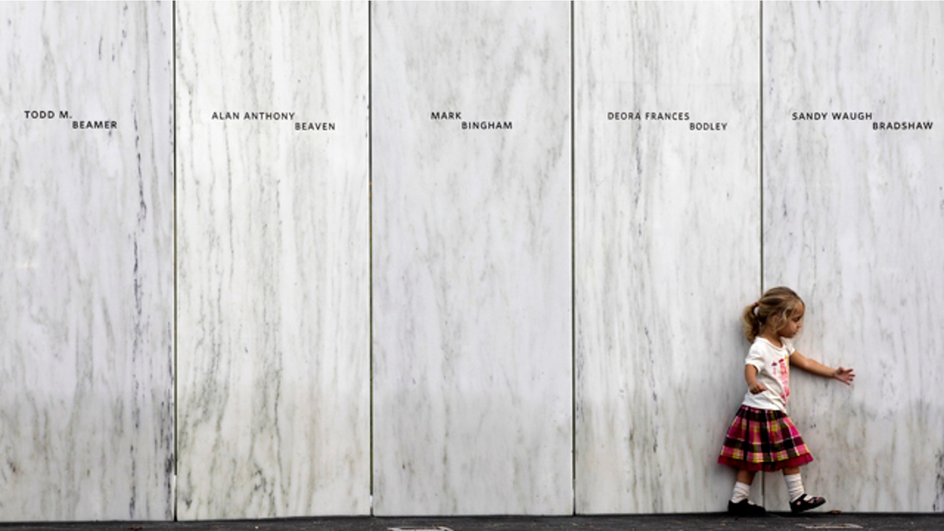 Sept 10: A family member of one of the victims of the crash of United Flight 93 walks along a section of Phase 1 of the permanent National Memorial following its dedication, near the crash site of Flight 93 in Shanksville, Pa. The names of the 40 victims of the crash are iny Sanscribed on the marble panels.
