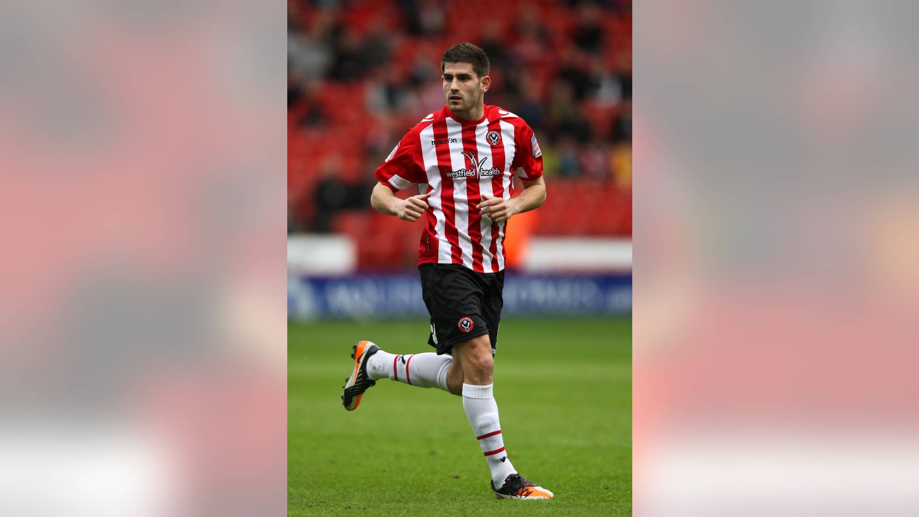 FILE - This March 17, 2013 file photo of footballer Ched Evans at Sheffield United. The former Premier League footballer who was convicted of rape has been told he can resume training with third tier club Sheffield United amid a national debate about the decision. (AP Photo/Nick Potts, PA) UNITED KINGDOM OUT