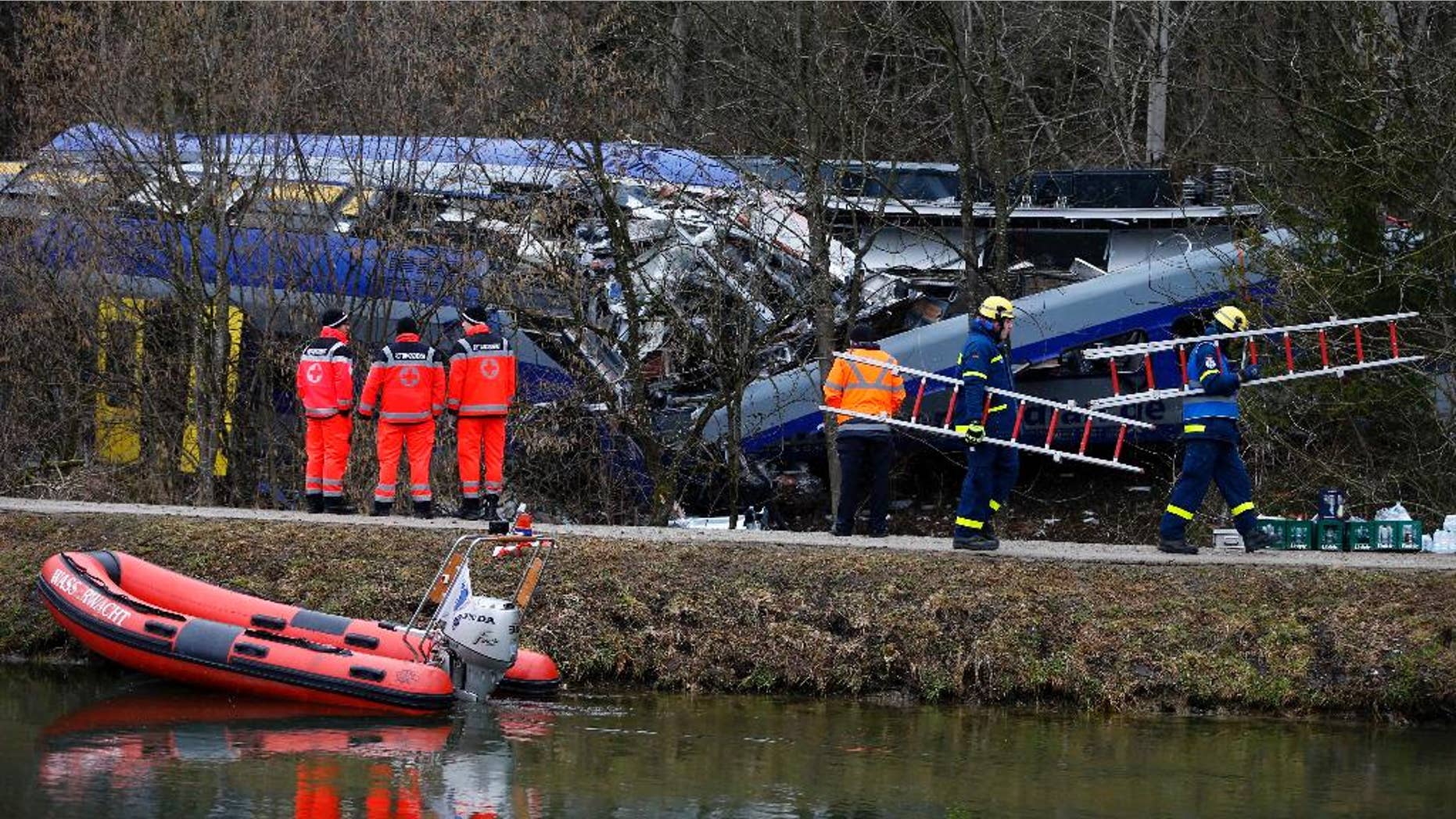 FILE - In this Feb. 10, 2016 file picture rescue personnel stand in front of trains that collided head-on near Bad Aibling, Germany. Prosecutors are seeking a four-year jail sentence for a train dispatcher accused of negligence that led to one of the worst train crashes in Germany history earlier this year. Twelve people died and 89 people were injured when two commuter trains collided on a single track Feb. 9 near the Bavarian town of Bad Aibling,southeast of Munic. ( Photo/Matthias Schrader,file)