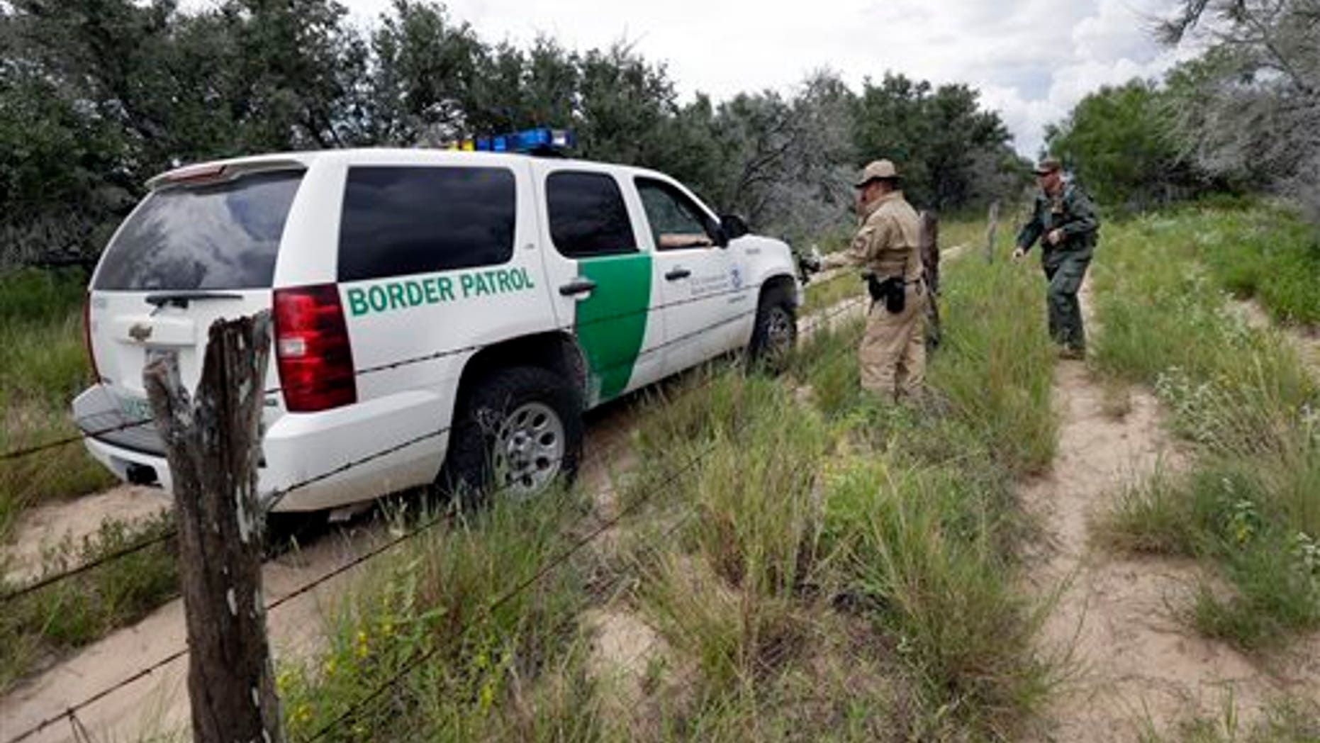 In this Sept. 5, 2014 photo, a U.S. Customs and Border Protection Air and Marine agents and U.S. Customs and Border Protection agents compare notes as they patrol near the Texas-Mexico border, near McAllen, Texas. Since illegal immigration spiked in the Rio Grande Valley this summer, the Border Patrol has dispatched more agents, the Texas Department of Public Safety has sent more troopers and Gov. Rick Perry deployed as many as 1,000 guardsmen to the area. (AP Photo/Eric Gay)