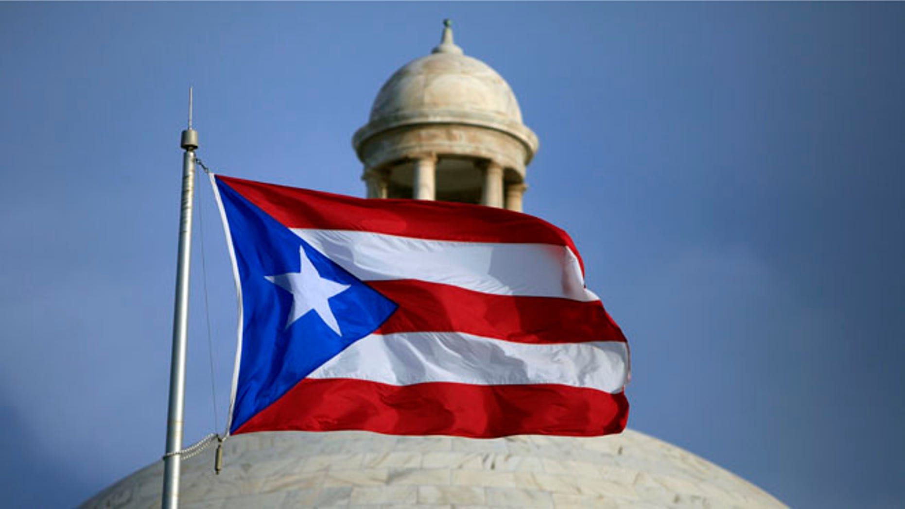 FILE - In this Wednesday, July 29, file 2015 photo, the Puerto Rican flag flies in front of Puerto Ricoâs Capitol as in San Juan, Puerto Rico. On Monday, April 11, 2016, Puerto Rico released a new proposal to restructure part of its $70 billion debt to buy time to implement a fiscal growth plan as multimillion-dollar payments loom for a U.S. territory facing dwindling cash reserves. (AP Photo/Ricardo Arduengo, File)