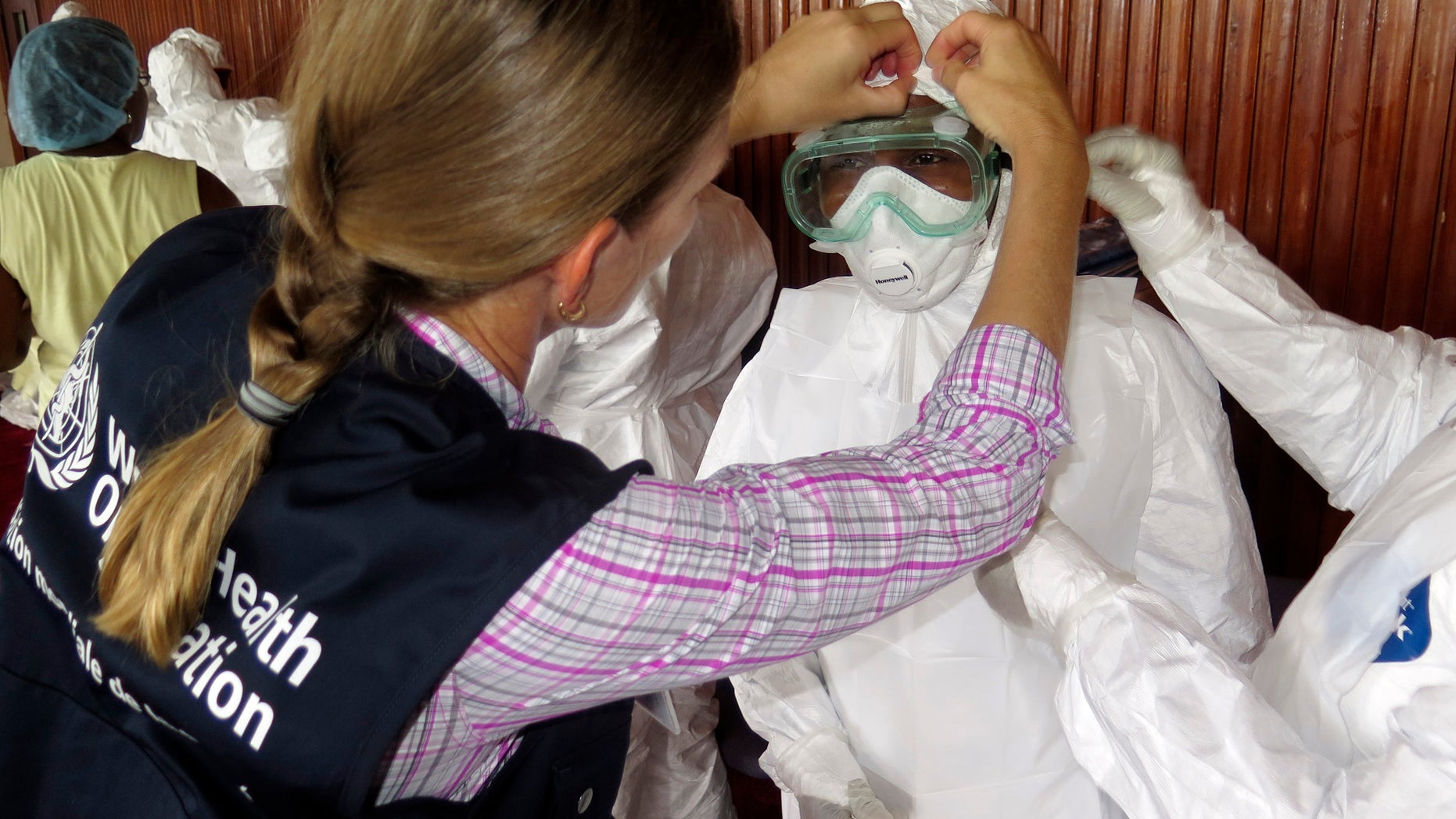 A World Health Organization (WHO) health worker gives a demonstration on the method of putting on a protective suit to health worker trainees in Freetown September 30, 2014. REUTERS/Umaru Fofana