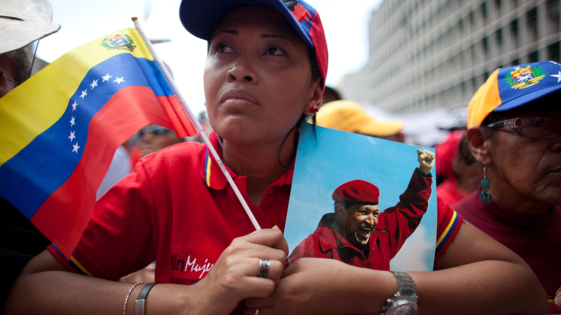 Un mujer sostiene una imagen del presidente de Venezuela Hugo Chávez durante una manifestación en Caracas, Venezuela, el miércoles 27 de febrero de 2013. Chávez está batallando por su salud y su vida, afirmó el jueves el vicepresidente Nicolás Maduro, quien aseguró el gobernante enfermó por entregarse a los pobres. (AP foto/Ariana Cubillos)