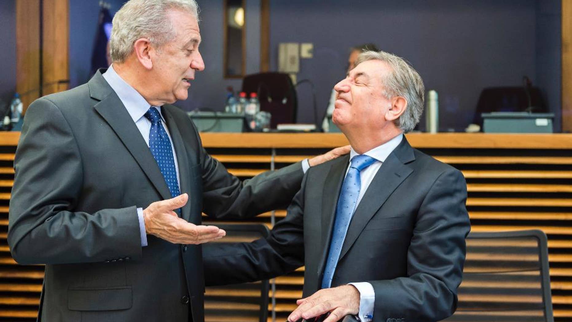 European Commissioner for Migration, Home Affairs and Citizenship Dimitris Avramopoulos, left, talks with European Commissioner for Environment, Maritime Affairs and Fisheries Karmenu Vella during the weekly meeting of commissioners at EU Commission headquarters in Brussels on Wednesday April 20, 2016. (AP Photo/Geert Vanden Wijngaert)